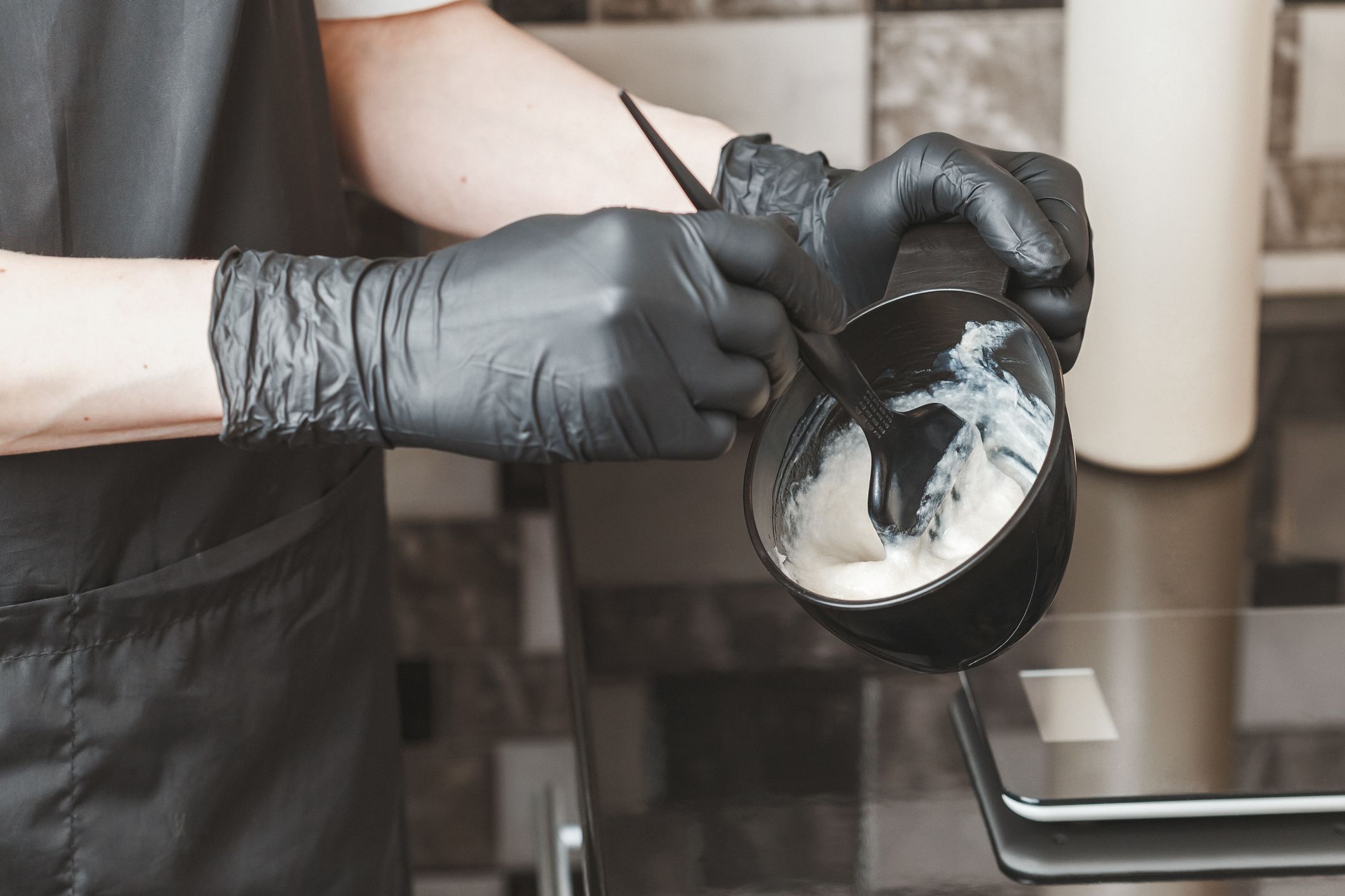 Stylist preparing a hair dye in a container