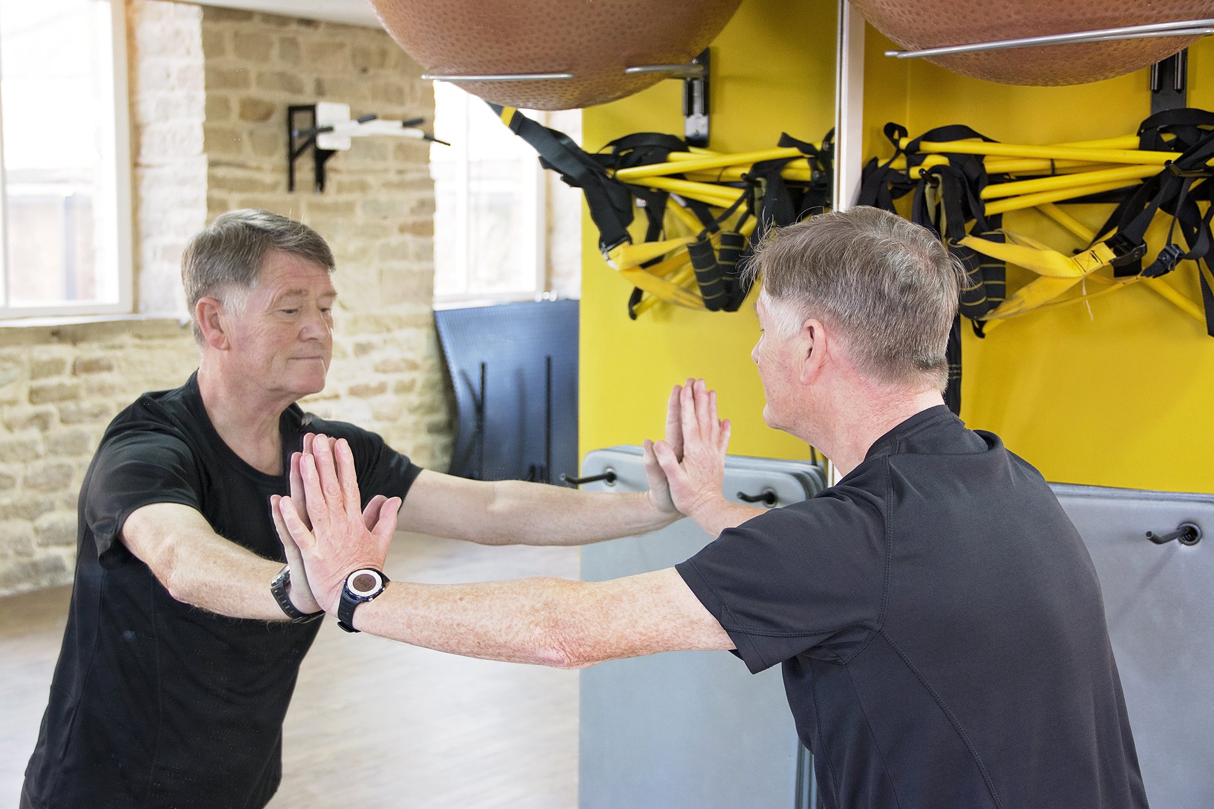 senior man doing press ups on gym mirror