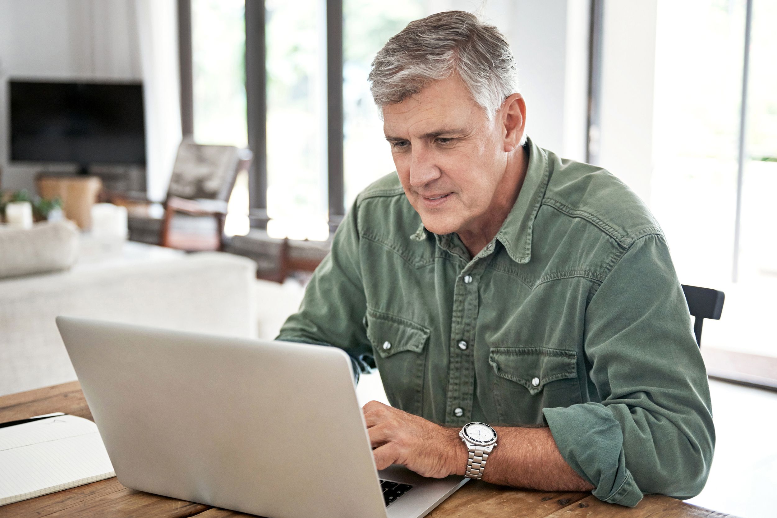 middle-aged man on laptop in house