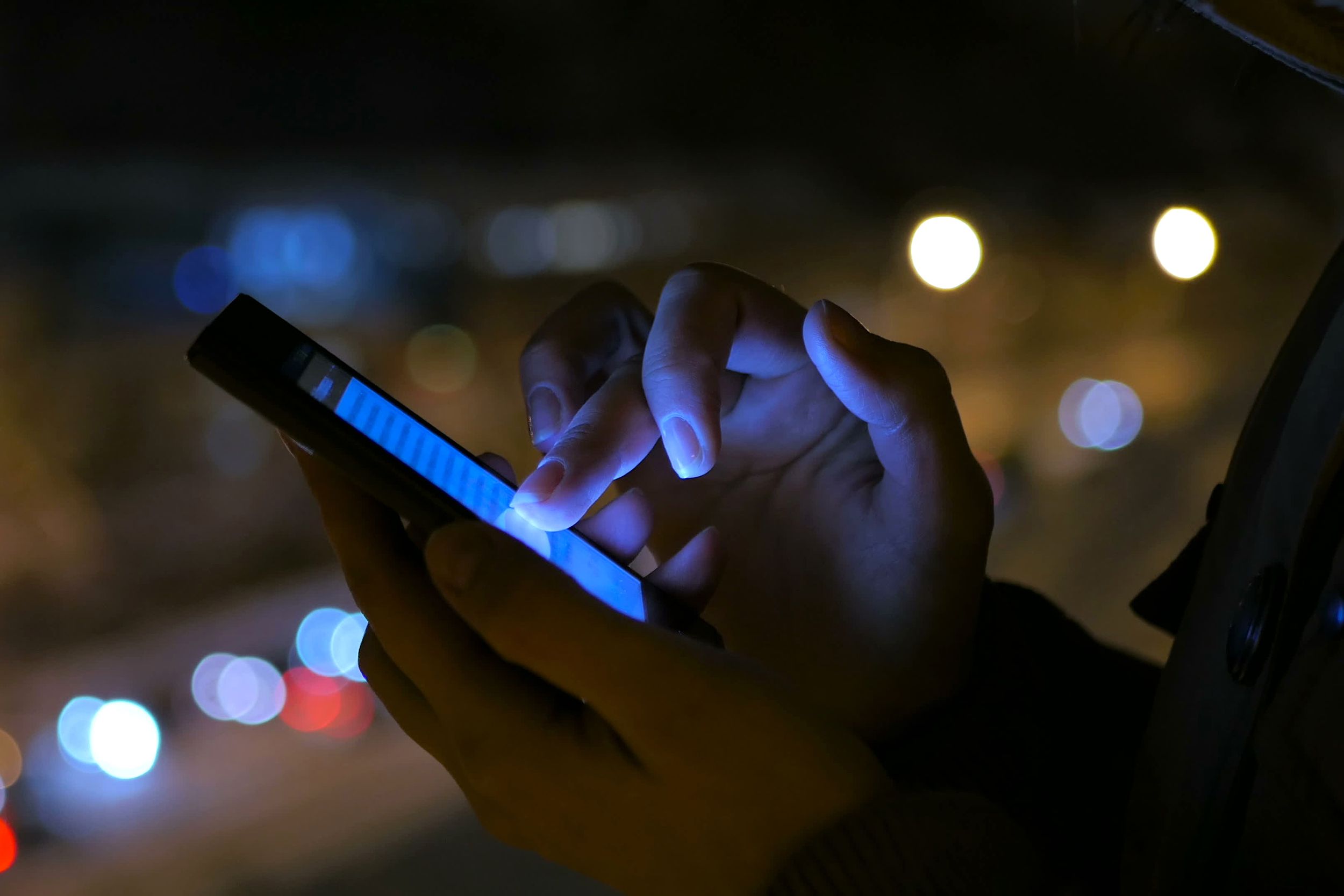 woman using smartphone in the city at night