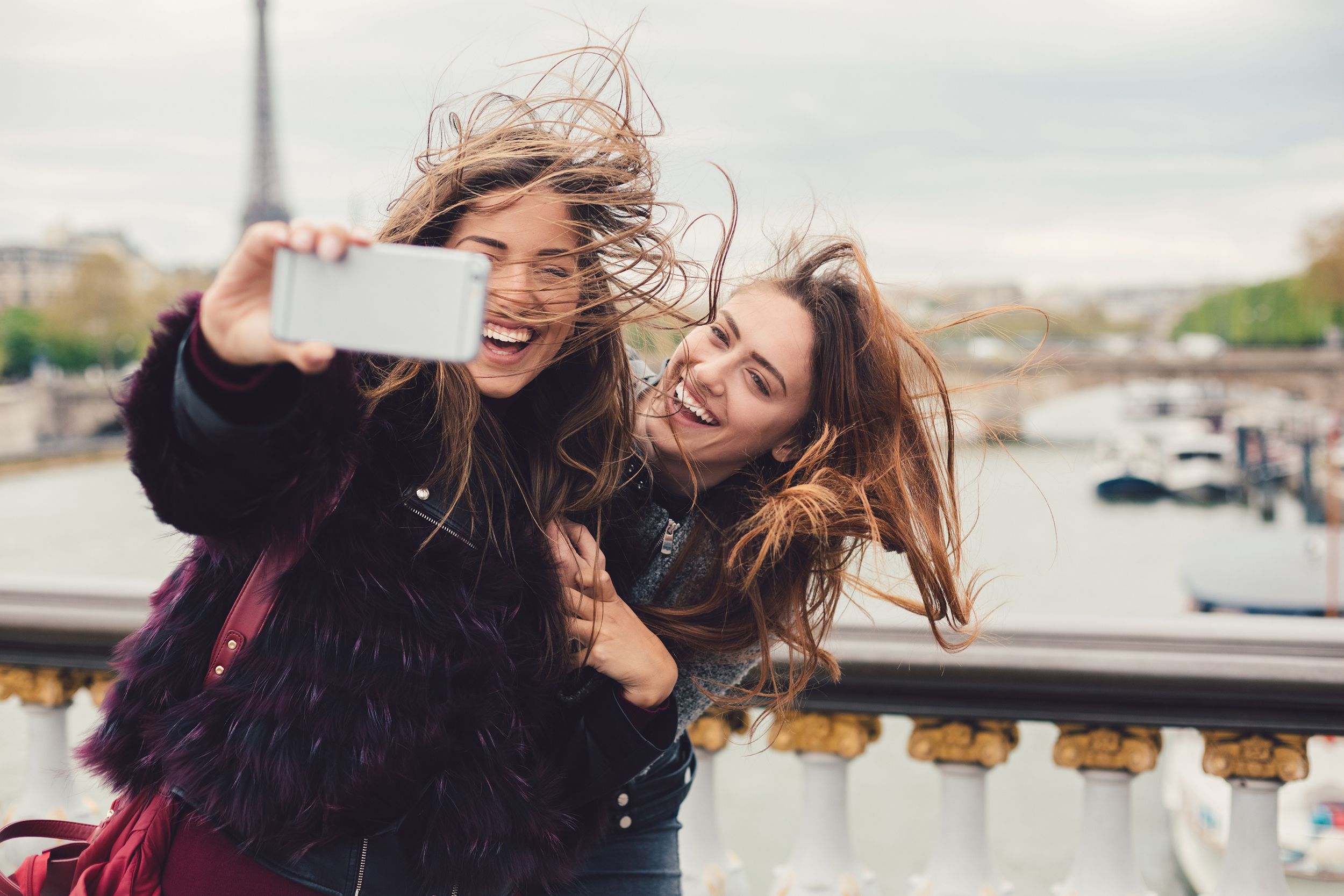 two young women taking seflie while enjoying vacation in Paris