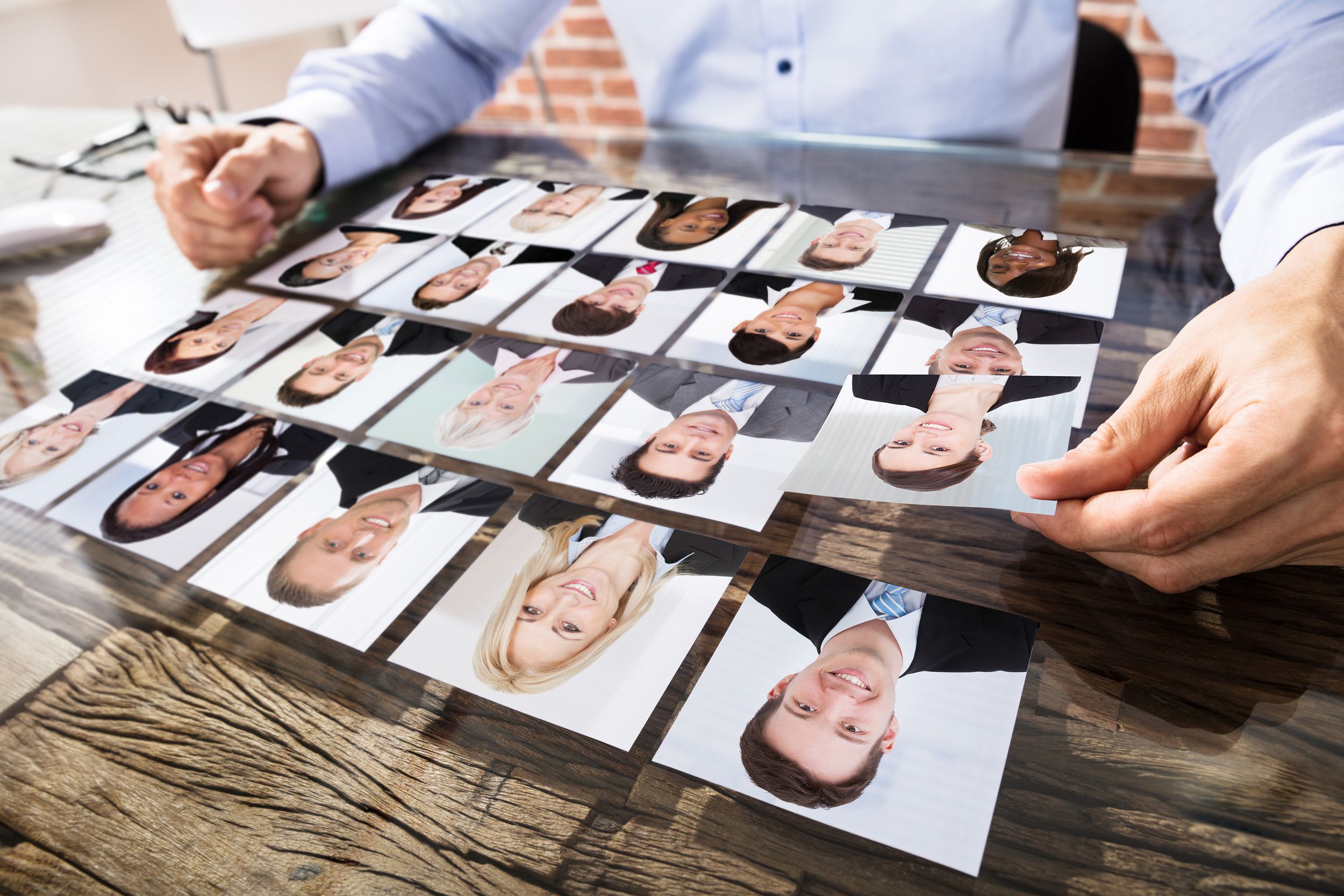 businessman making candidate selection with square images for job