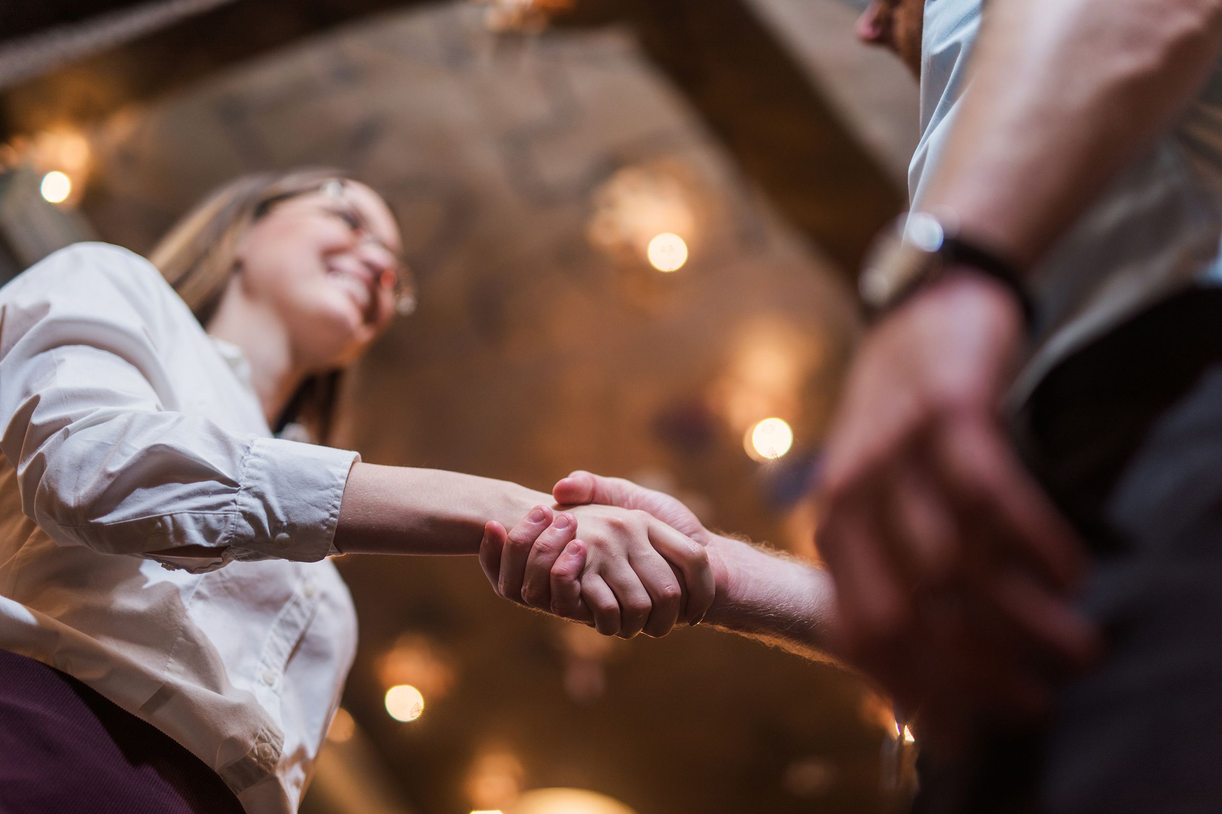 young woman shaking hands with work colleague