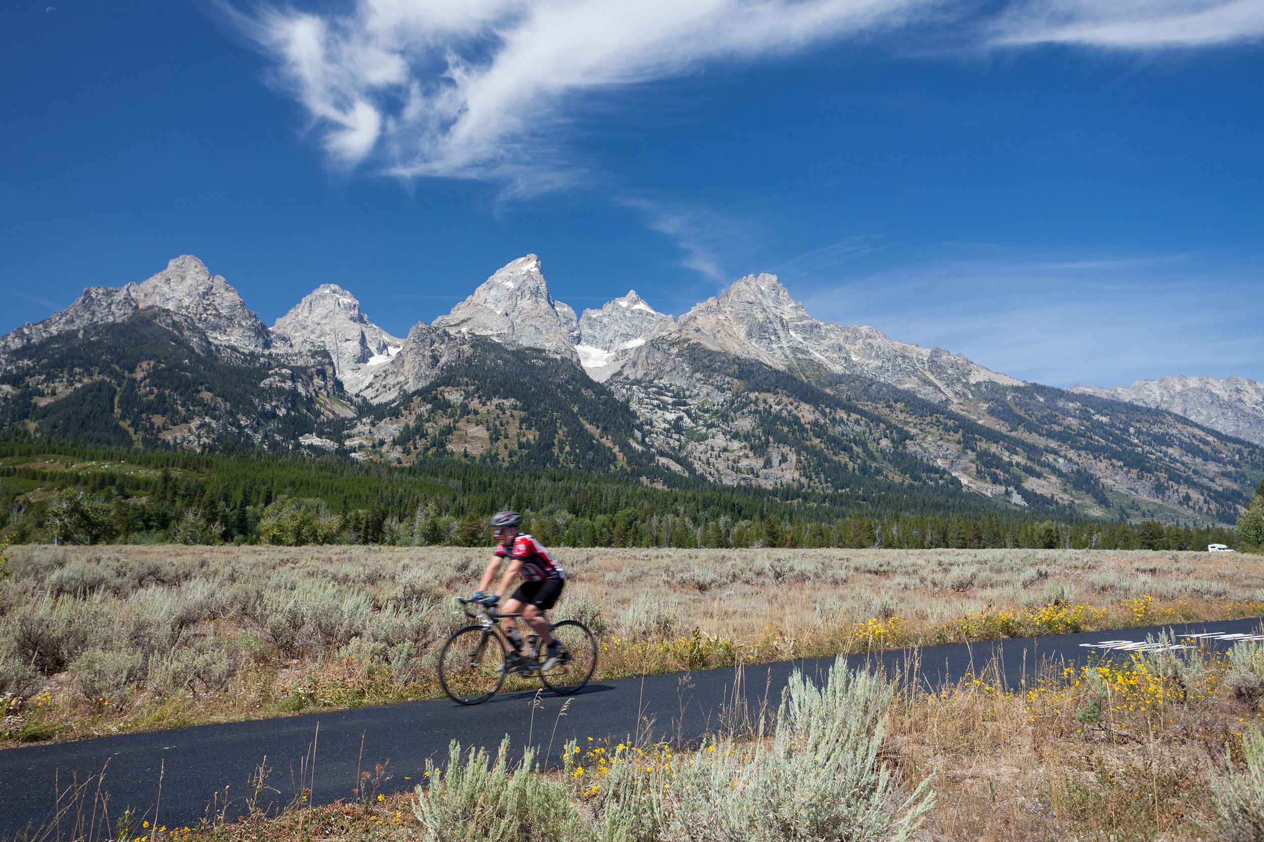athlete riding a bicycle on the path next Jenny Lake in the Grand Teton National Park