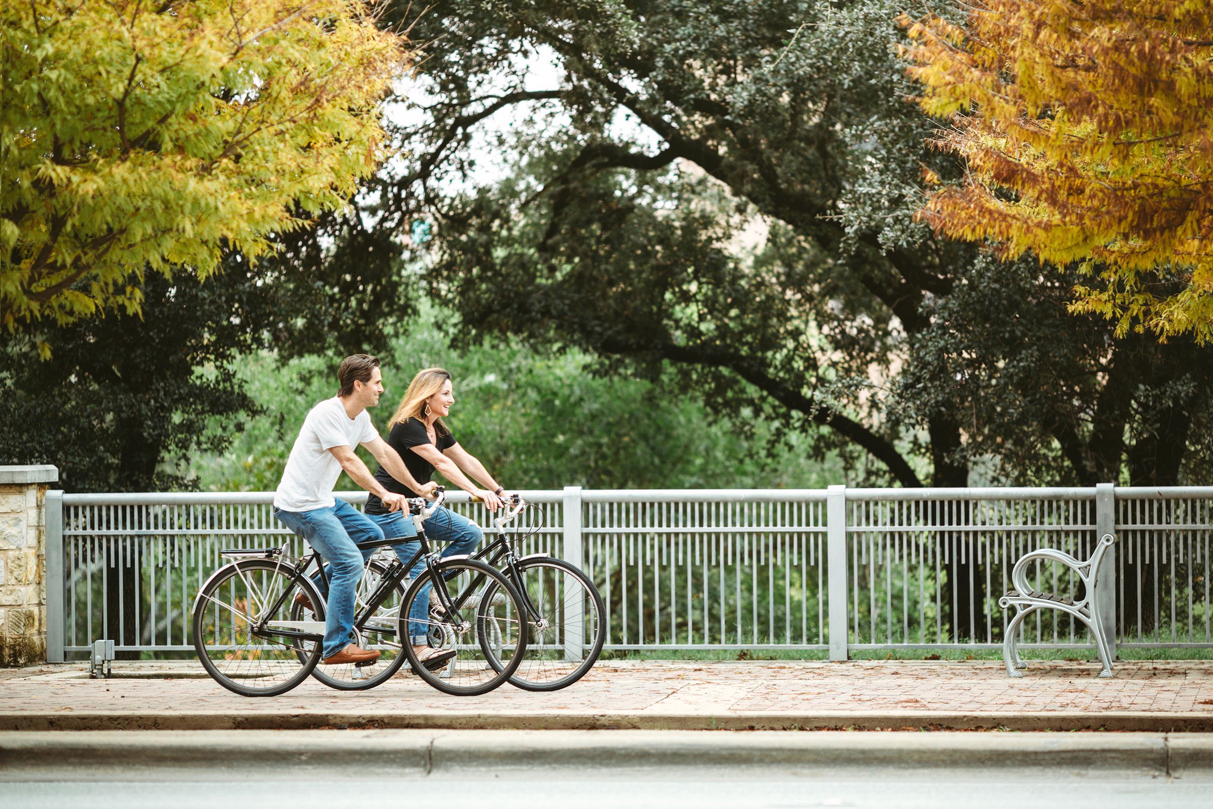couple in their mid 40's ride some cruiser bicycles around downtown Austin Texas