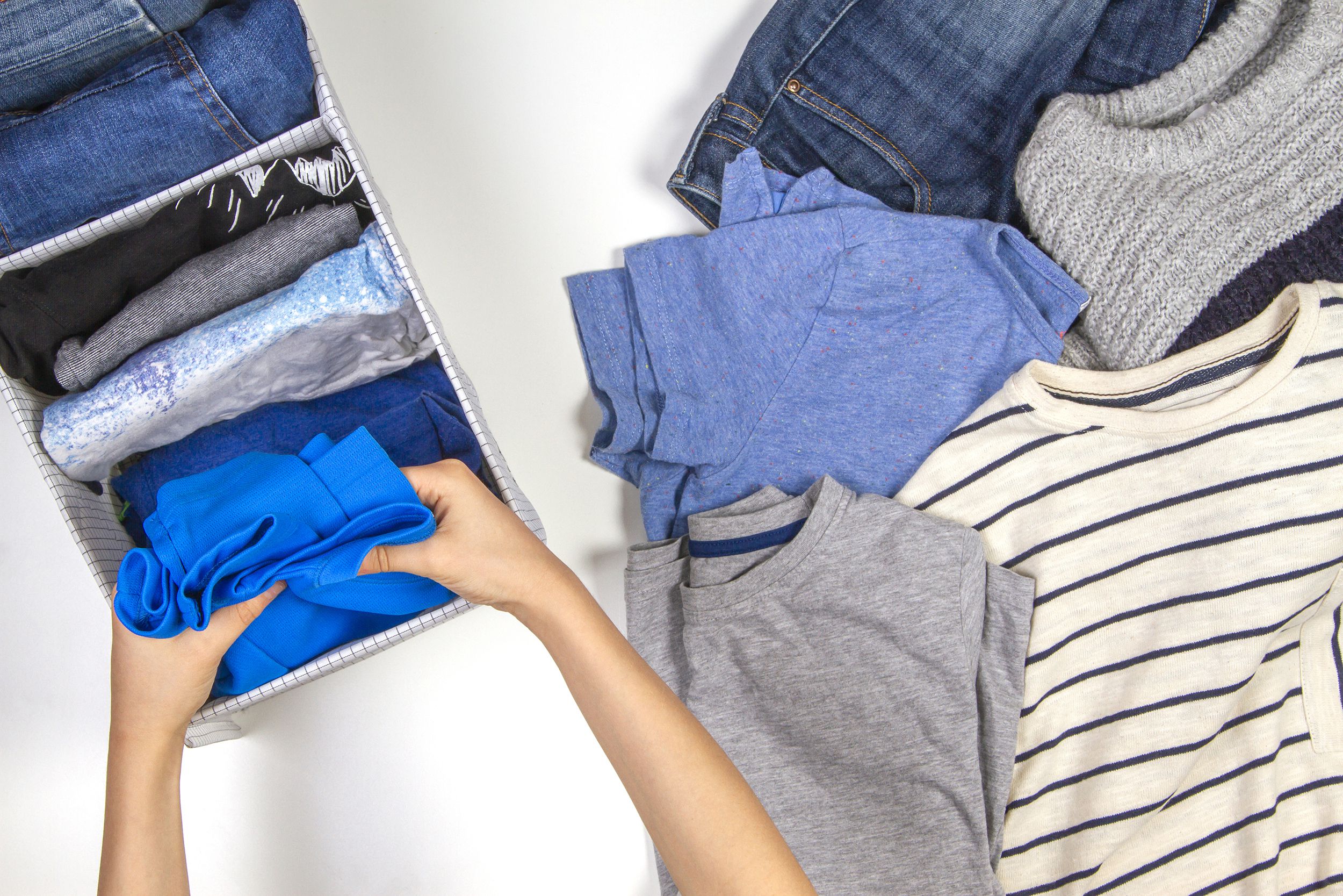 woman hands tidying up kids clothes in basket