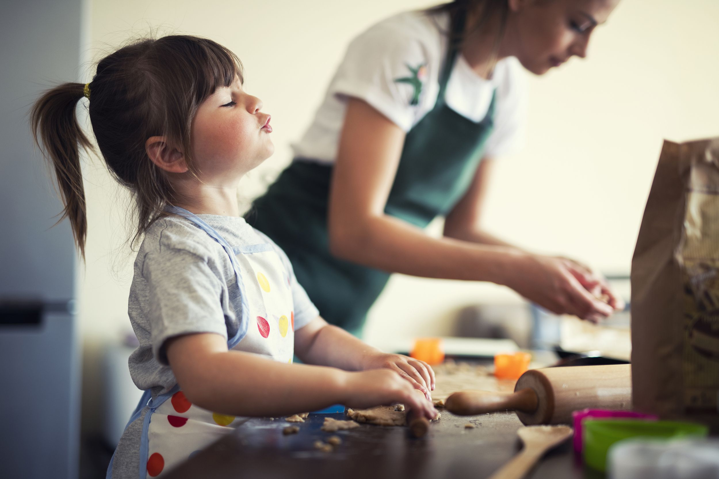 little girl baking at home with mom