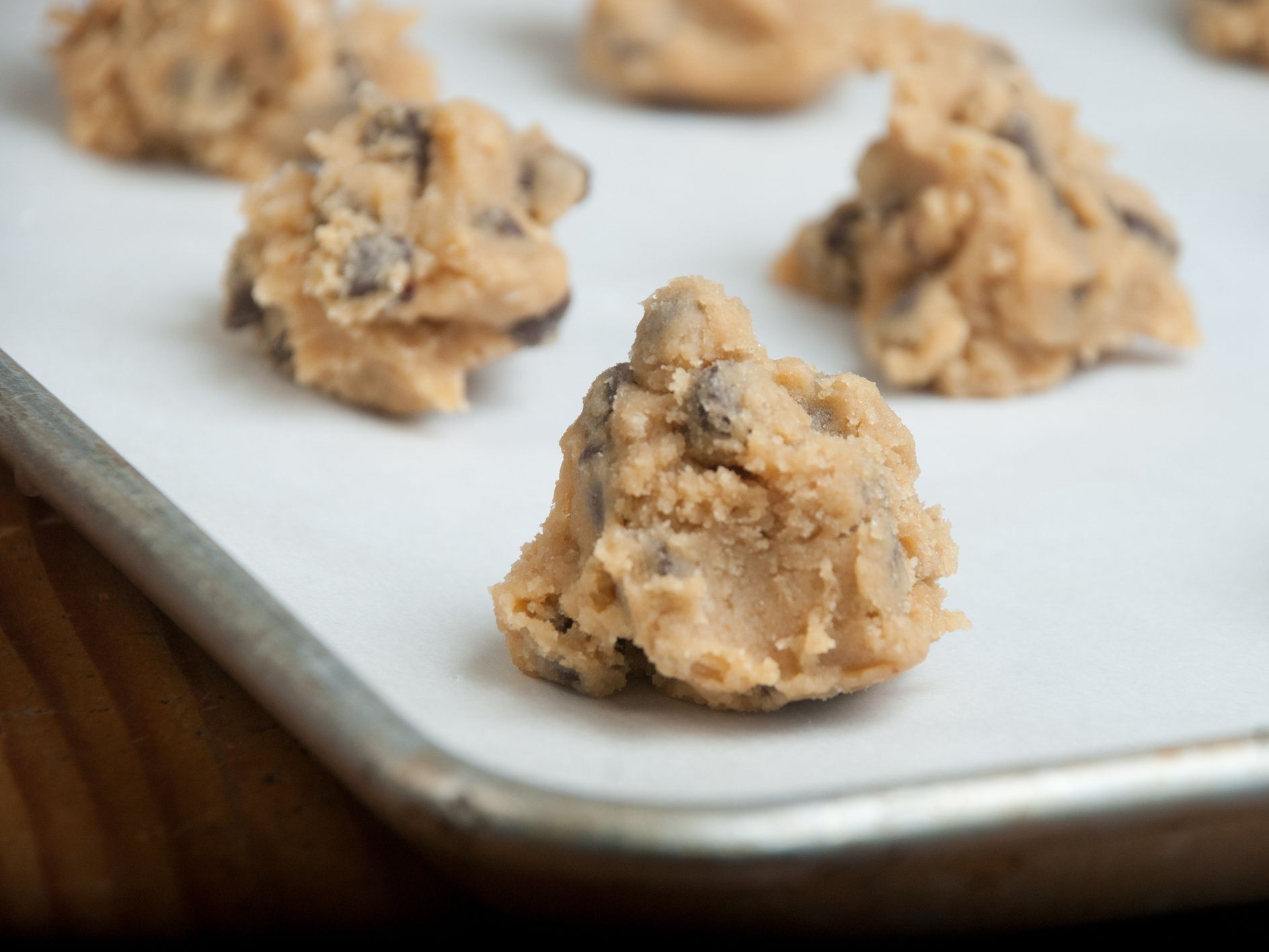 A pan of freshly prepared homemade chocolate chip cookie dough sits on the counter waiting to go into the oven.