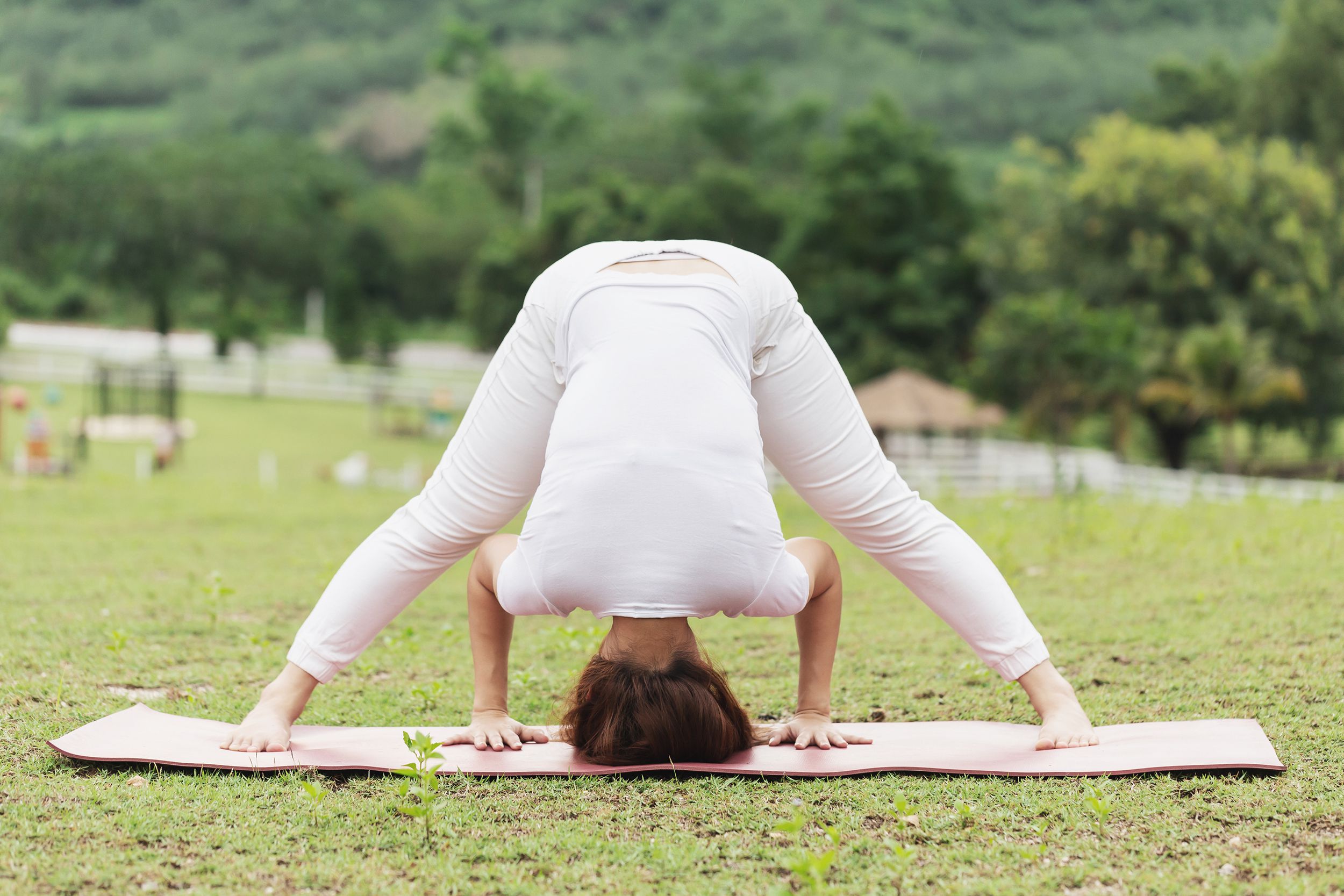 woman doing wide leg fold outside