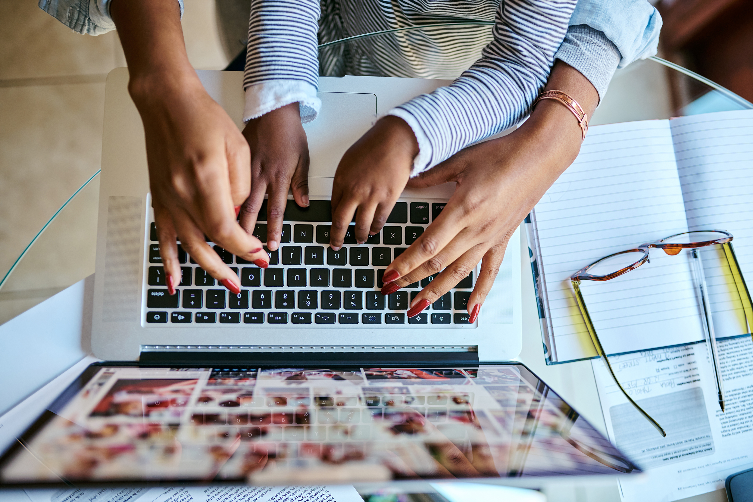 hands of mother and daughter typing on a laptop