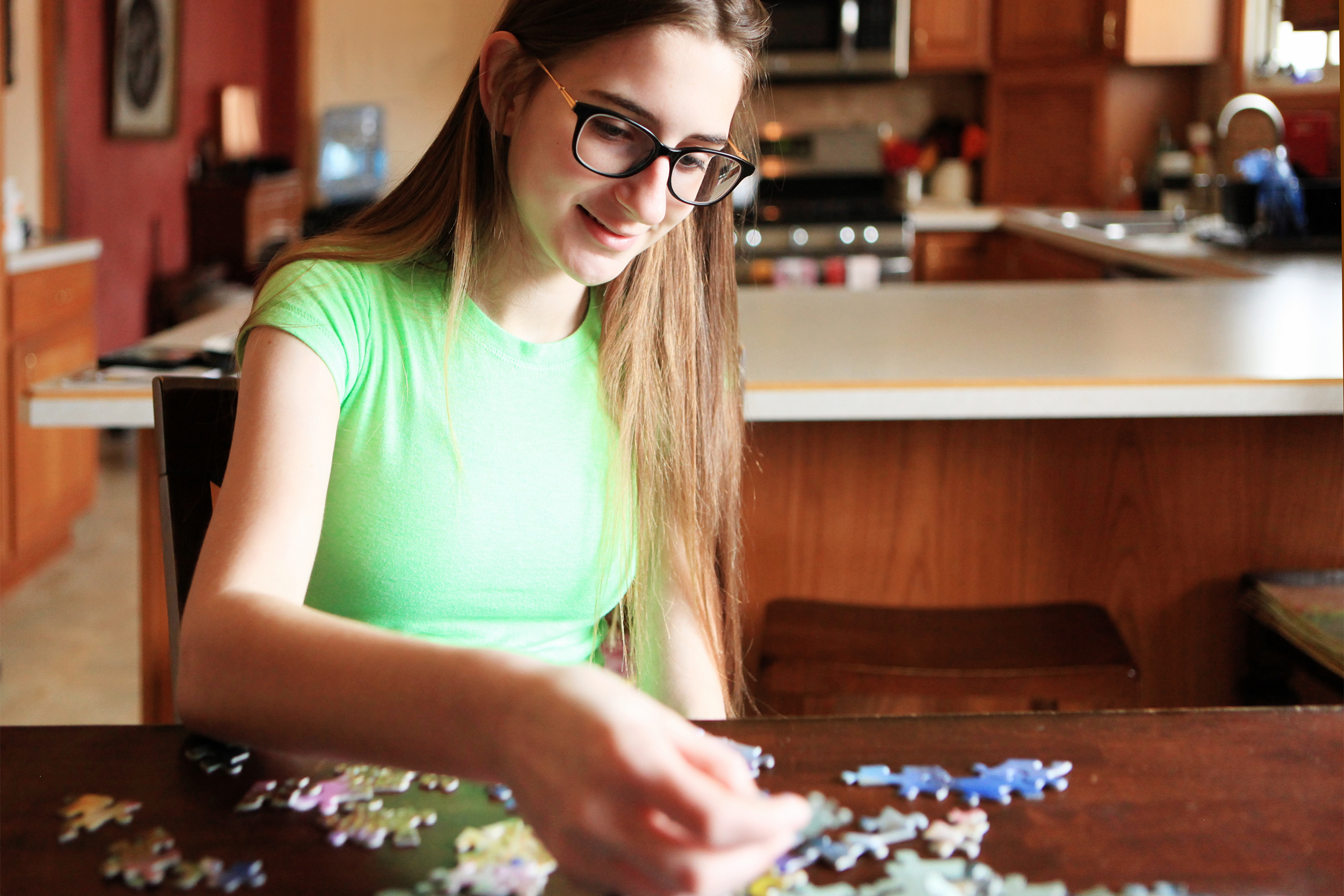 teenage girl doing a puzzle at home