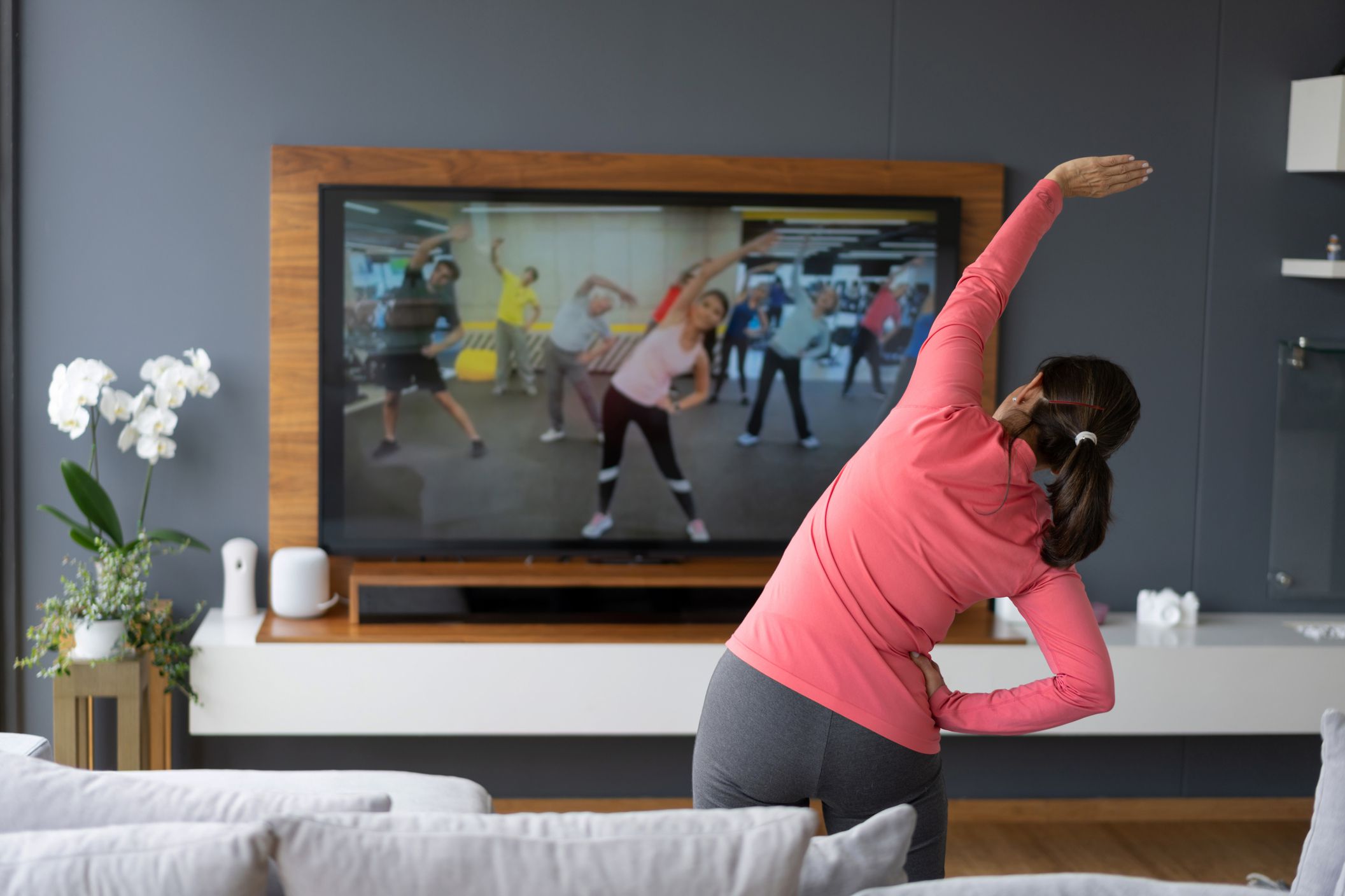 woman doing Aerobics Class following large tv screen
