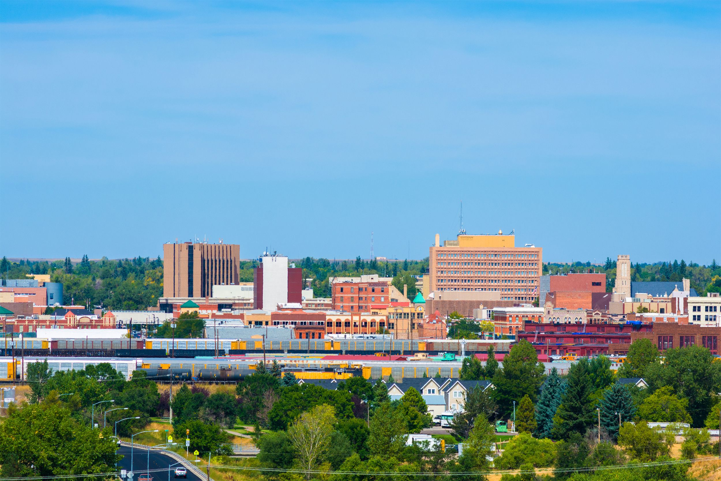 Cheyenne downtown skyline with train cars, houses, and trees in view in Wyoming