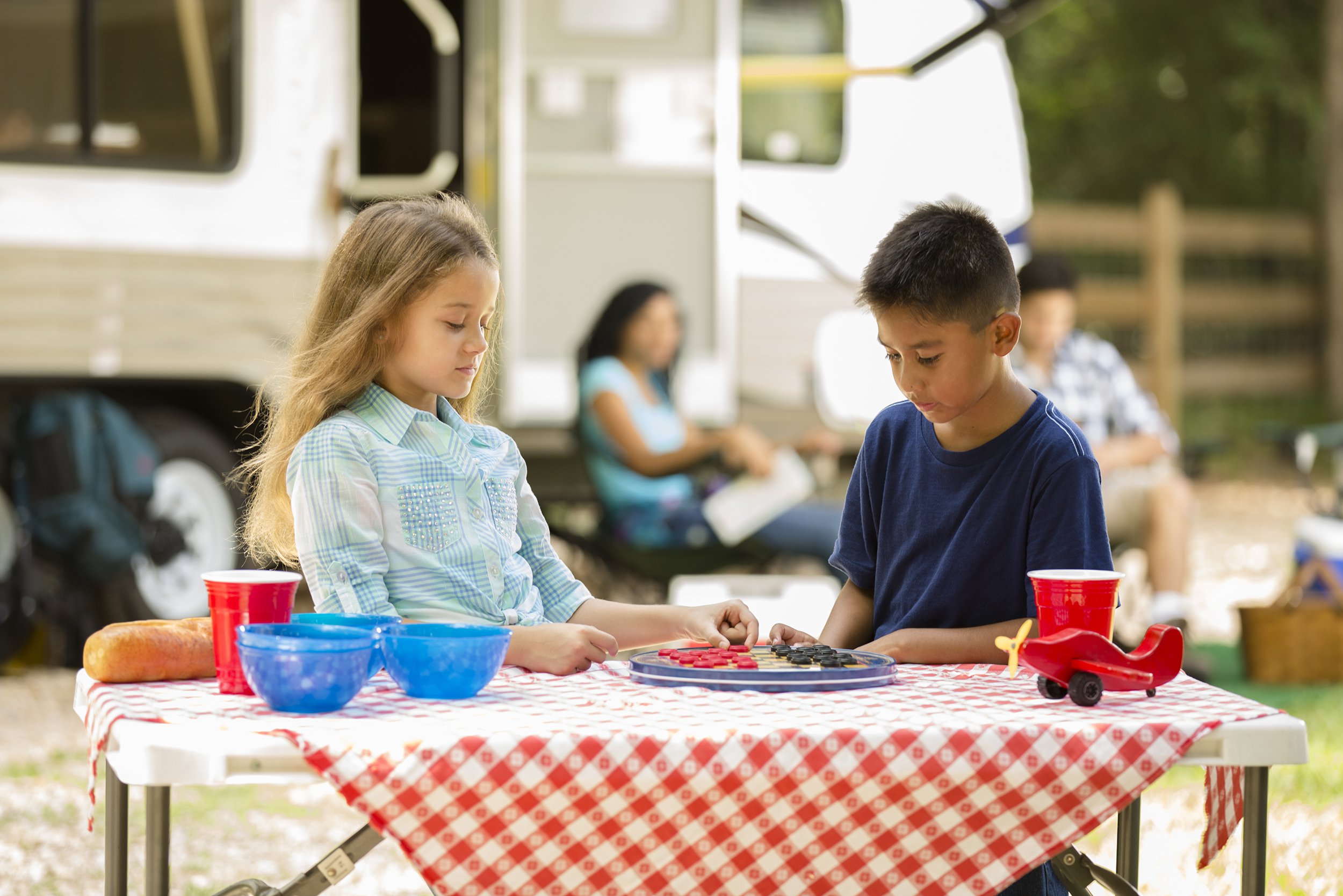 motor home parked at national park campground with two kids eating together