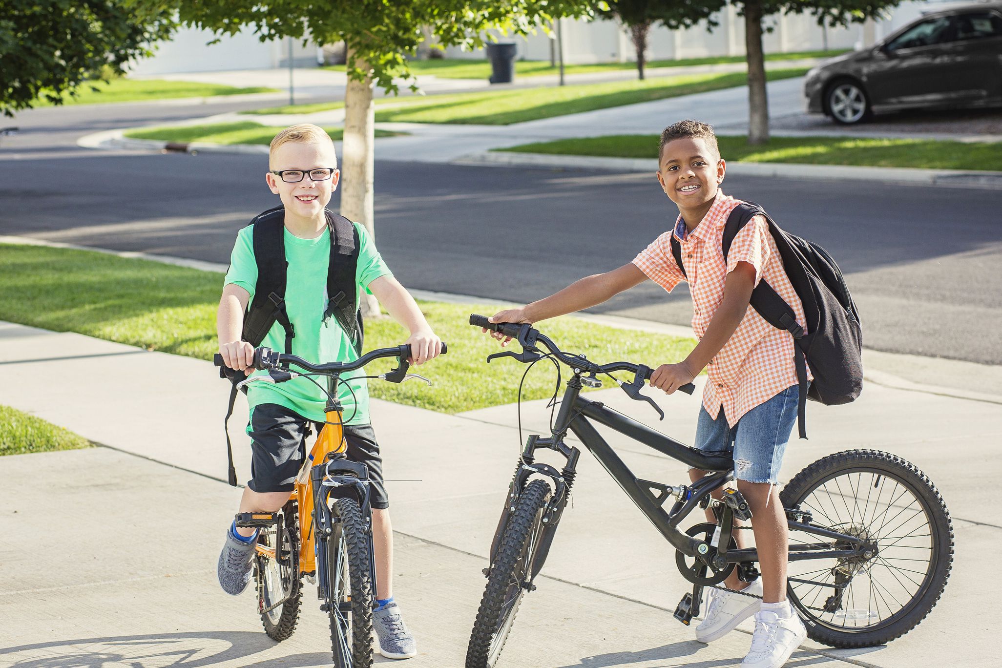 two children with bikes and school backpacks