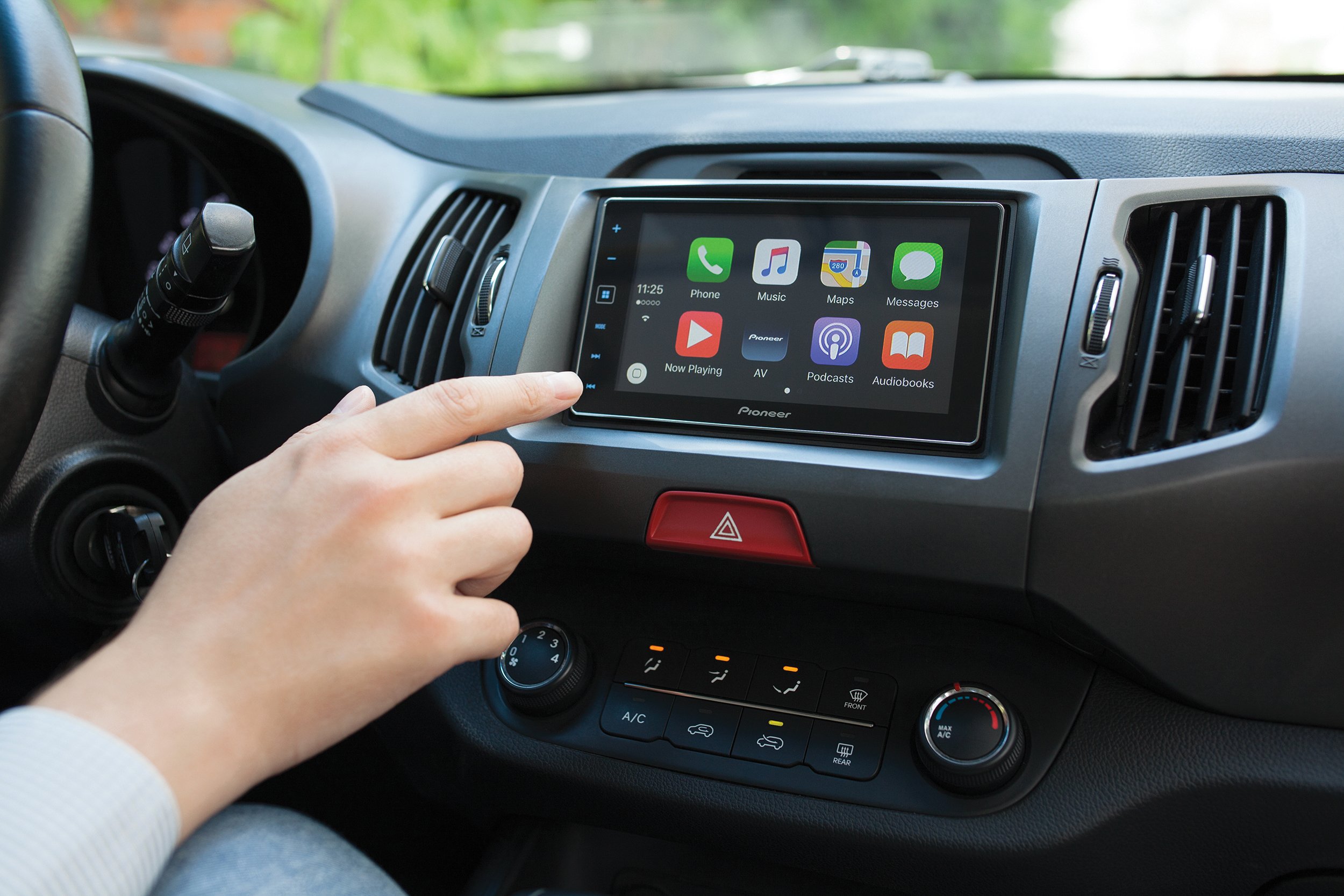 Hand touching a multimedia screen on a car
