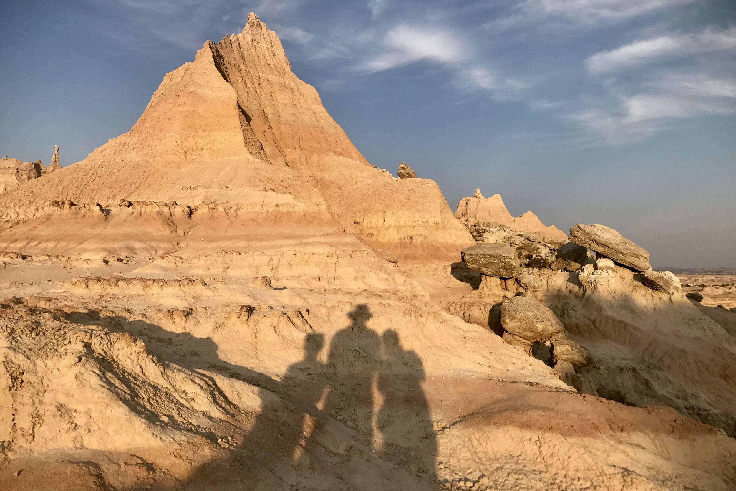 shadows of three family members against the jagged hills of the Badlands, South Dakota