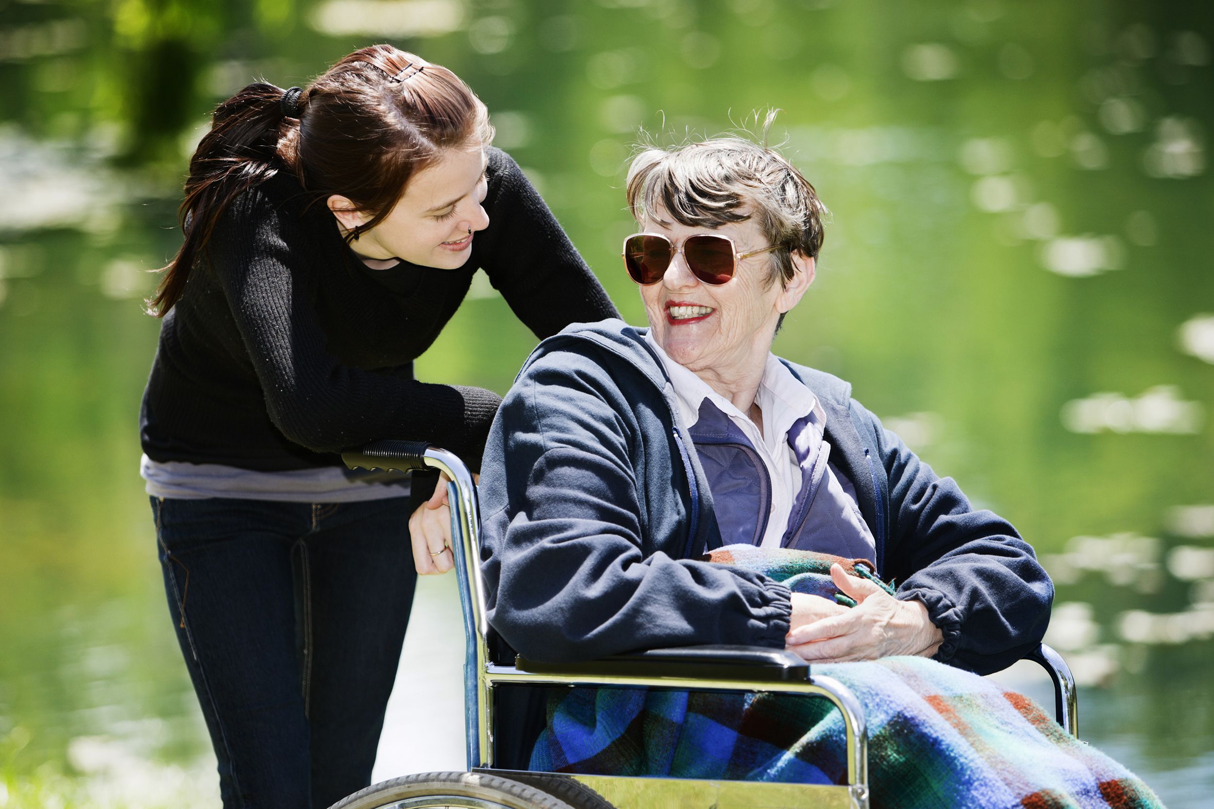 happy woman in wheelchair with young granddaughter