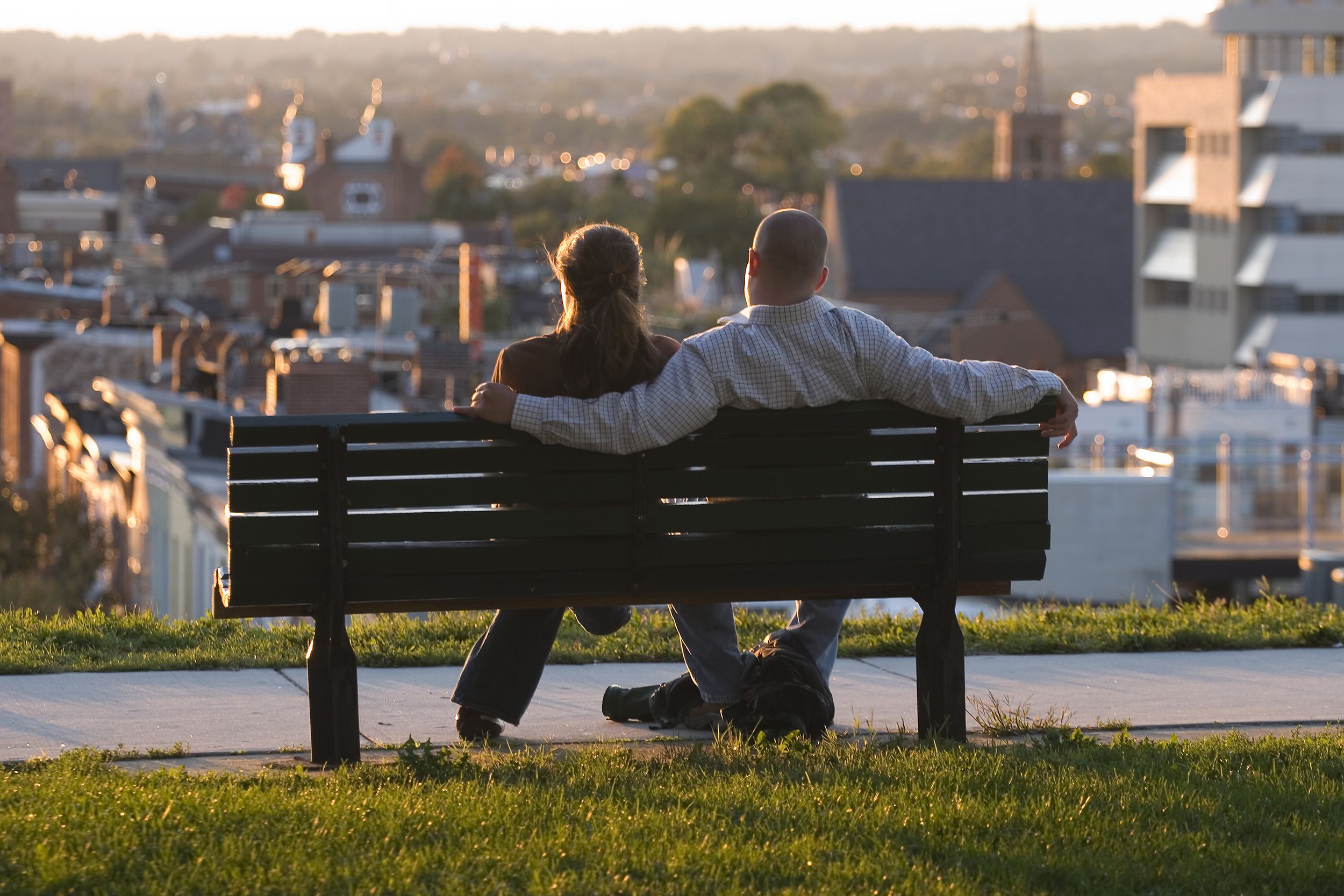 young couple watching the sun go down on a bench on Federal Hill in Baltimore, Maryland