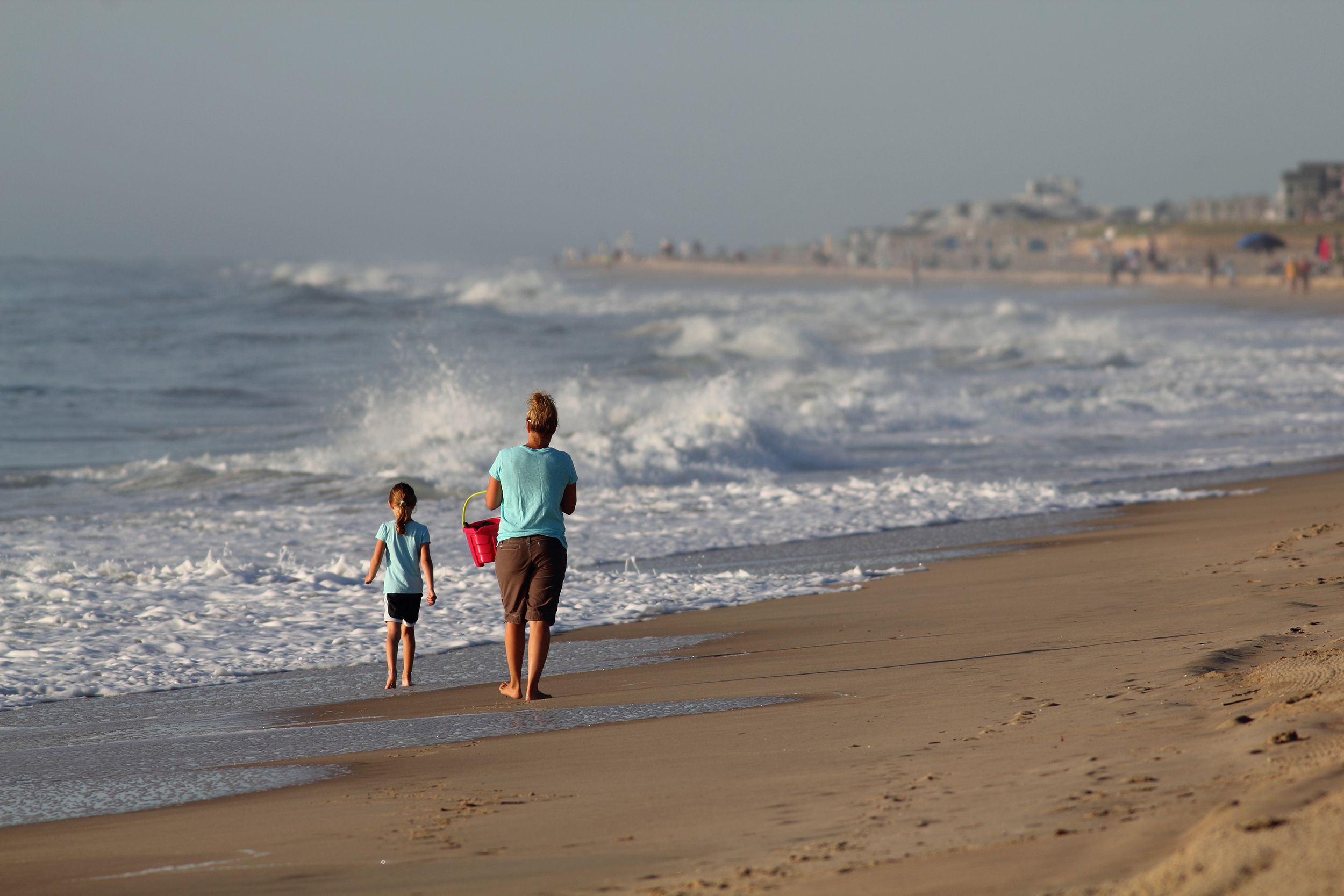 mother and daughter take a walk on the beach in the morning