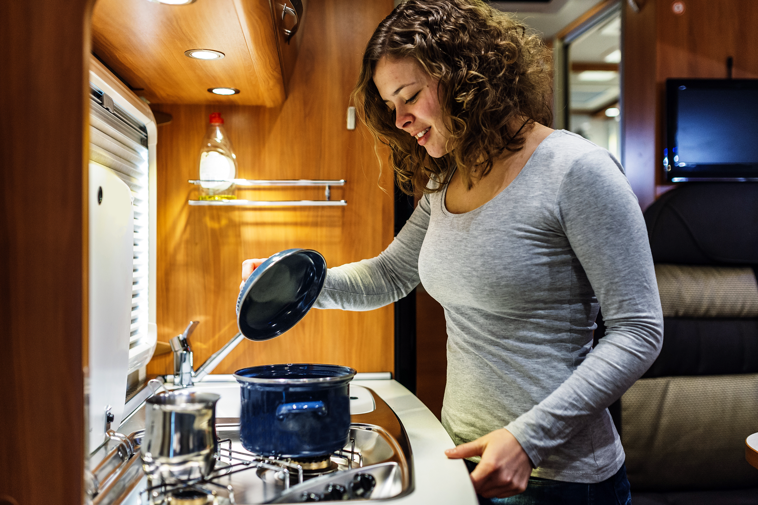 Woman cooking on the stove in an RV