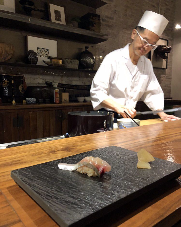 chef making sushi in background, sushi plate in foreground
