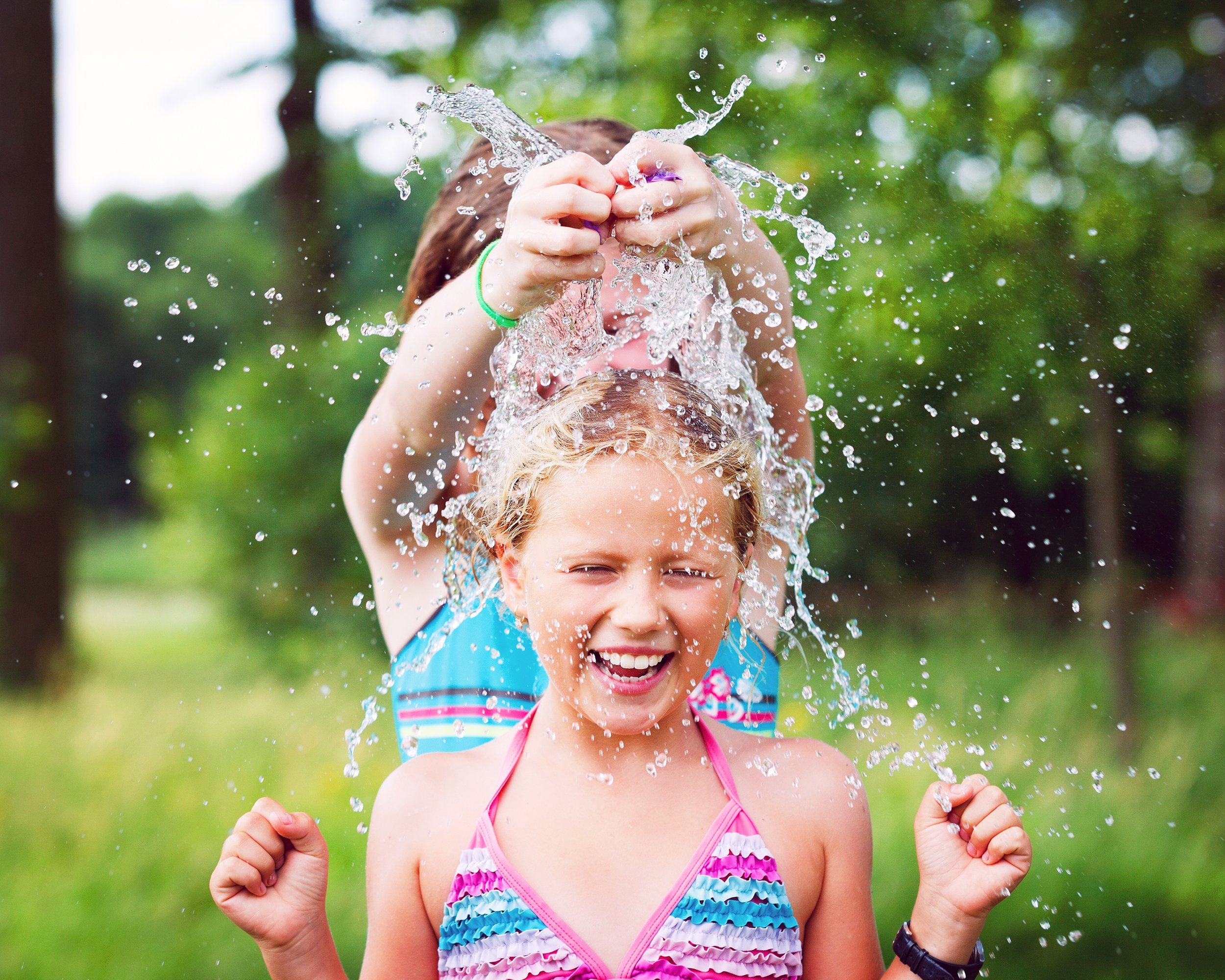 two kids having a water balloon fight