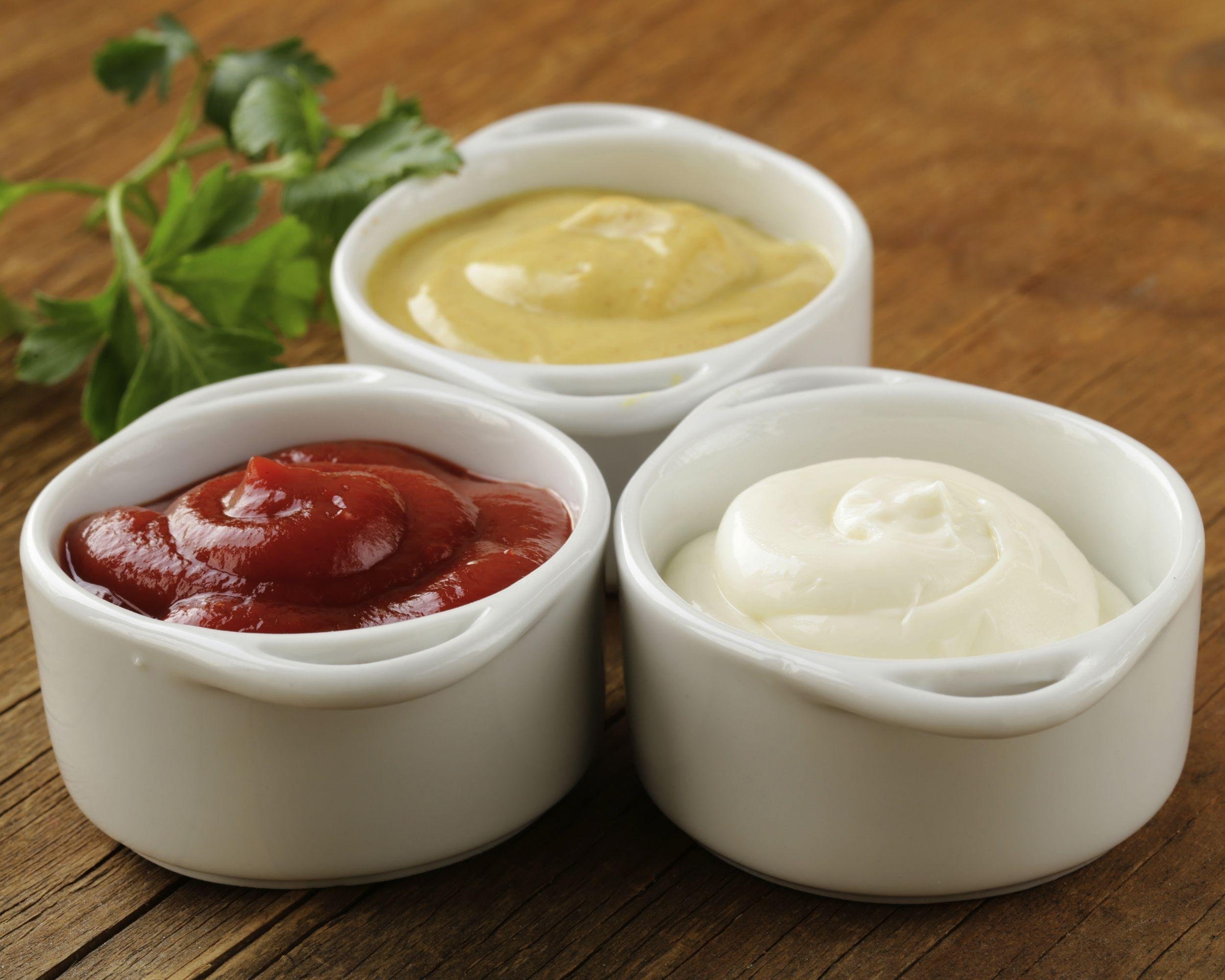 condiments in white bowls on table