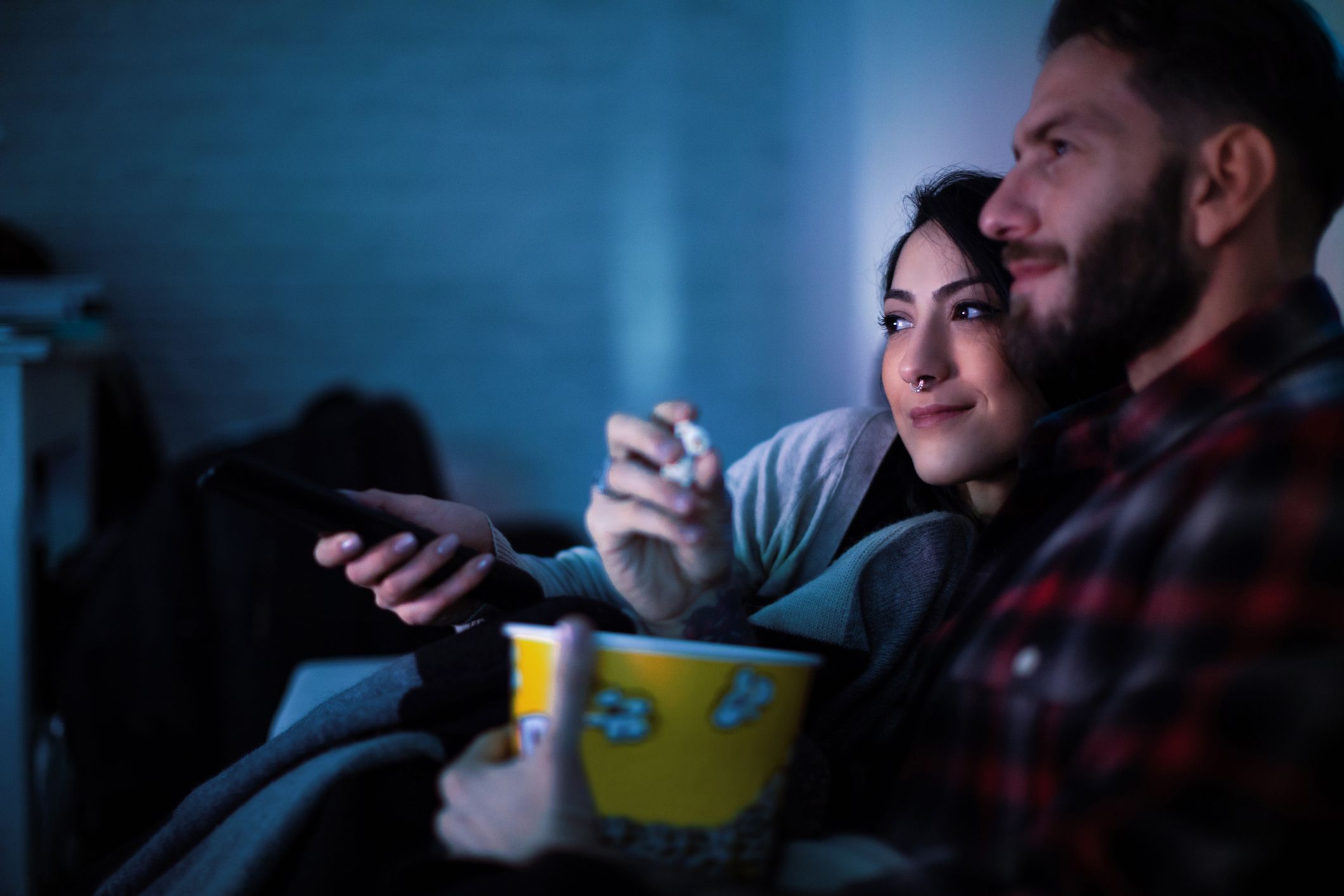 couple watching tv eating popcorn