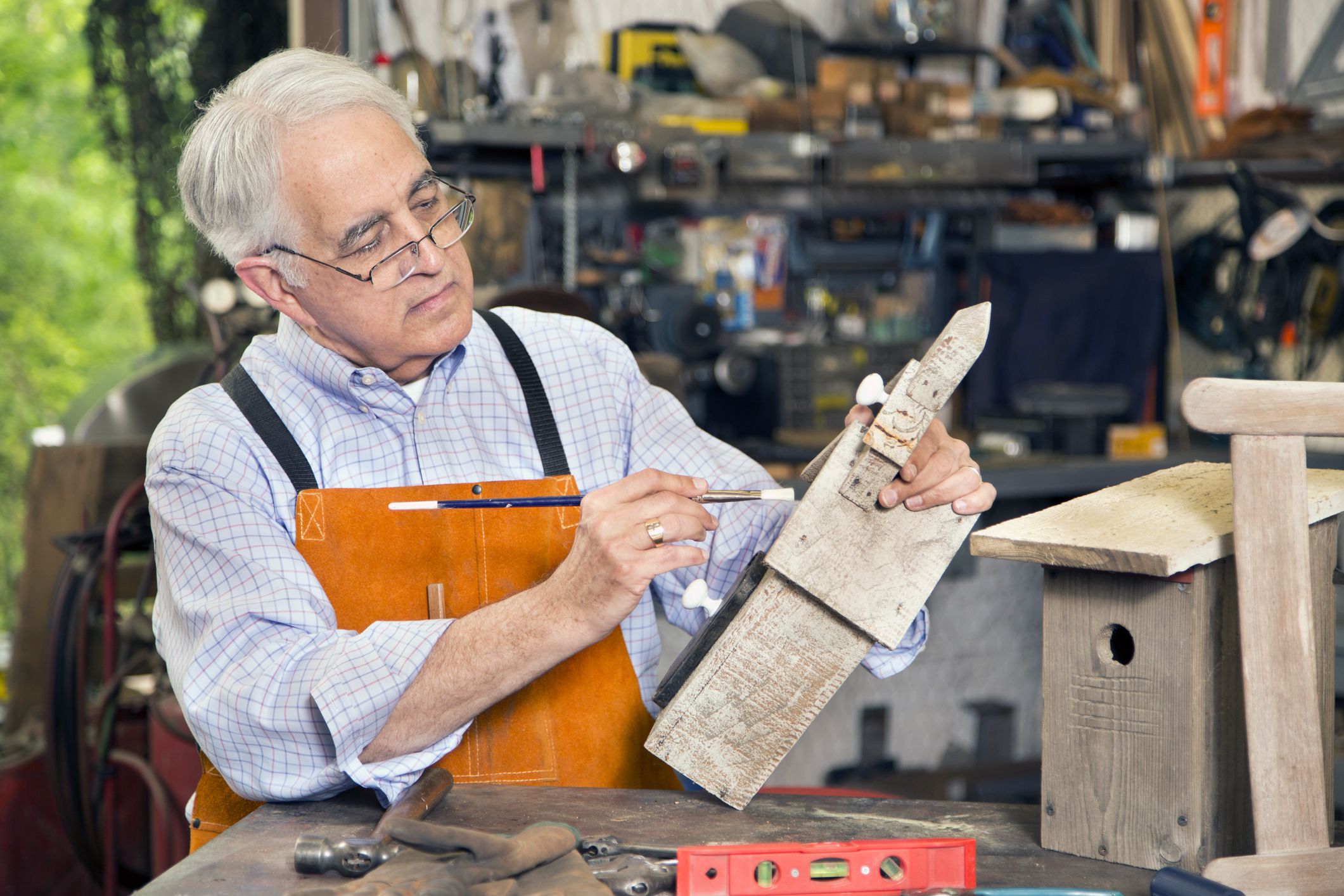 senior making birdhouse in garage
