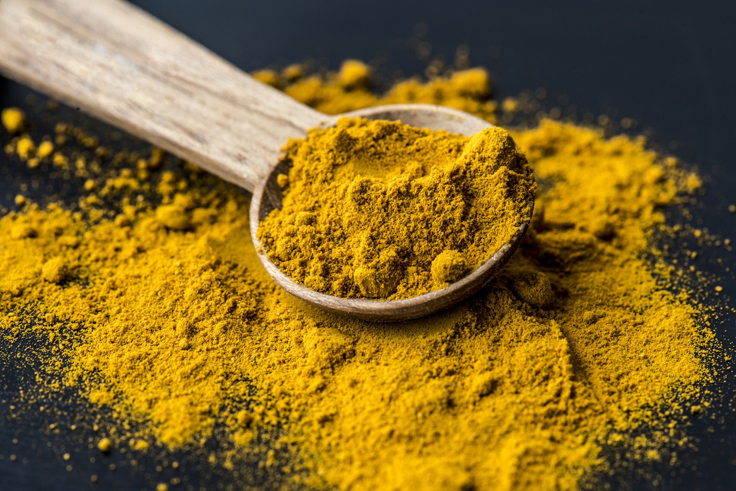 closeup of turmeric powder spice on a spoon