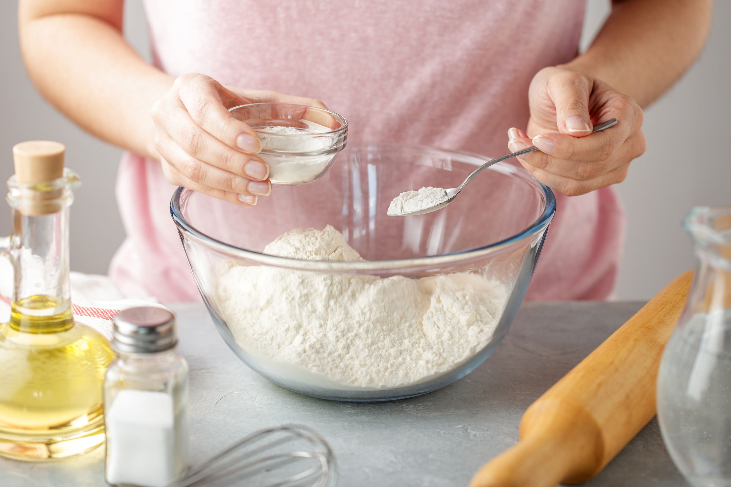 person mixing baking soda with flour in bowl