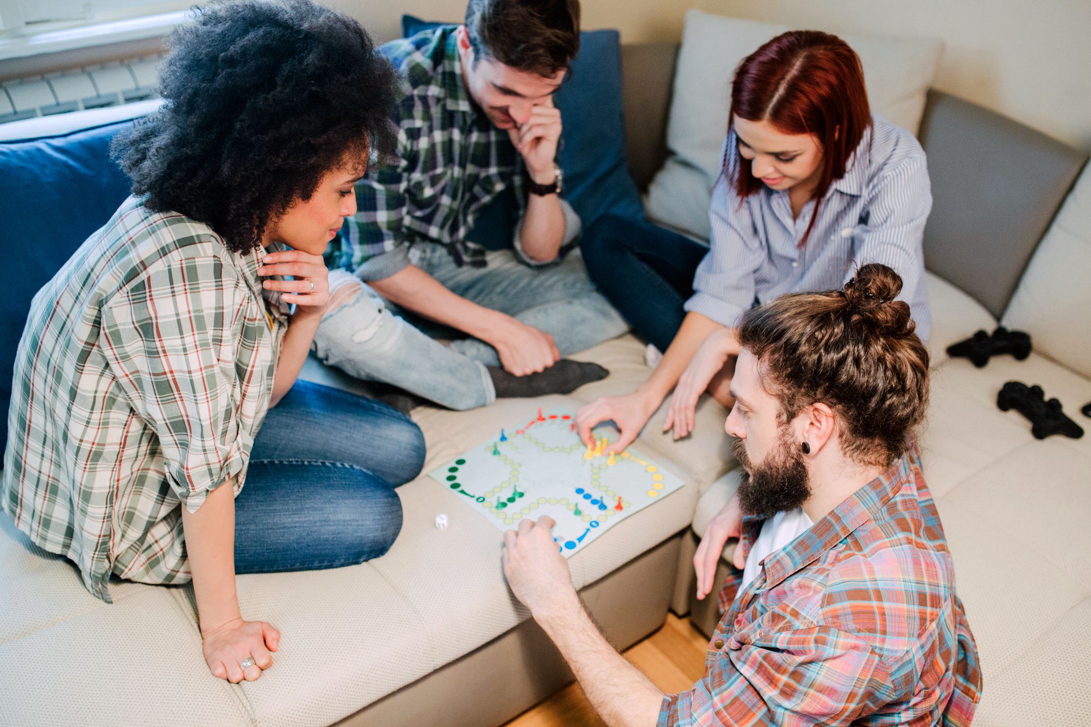 young folks playing board game on couch