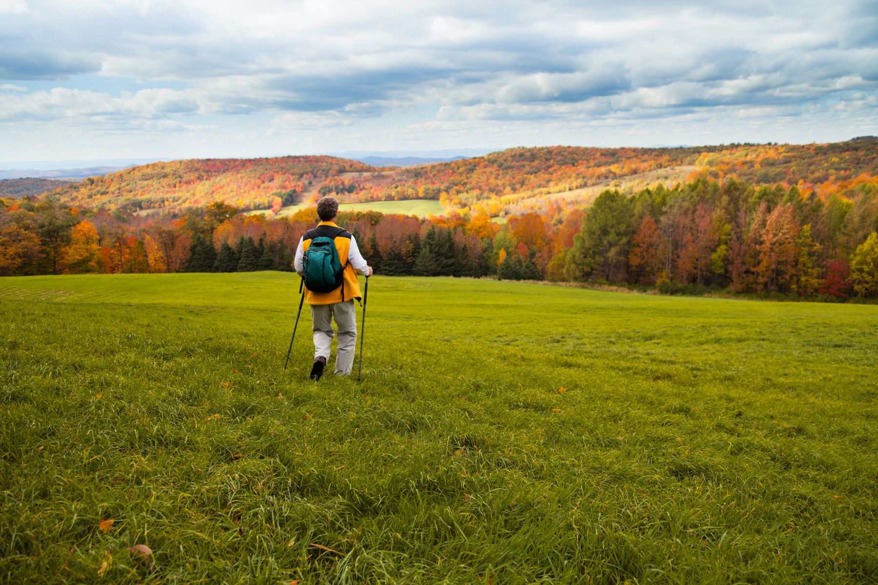 senior man hiking meadow in Vermont