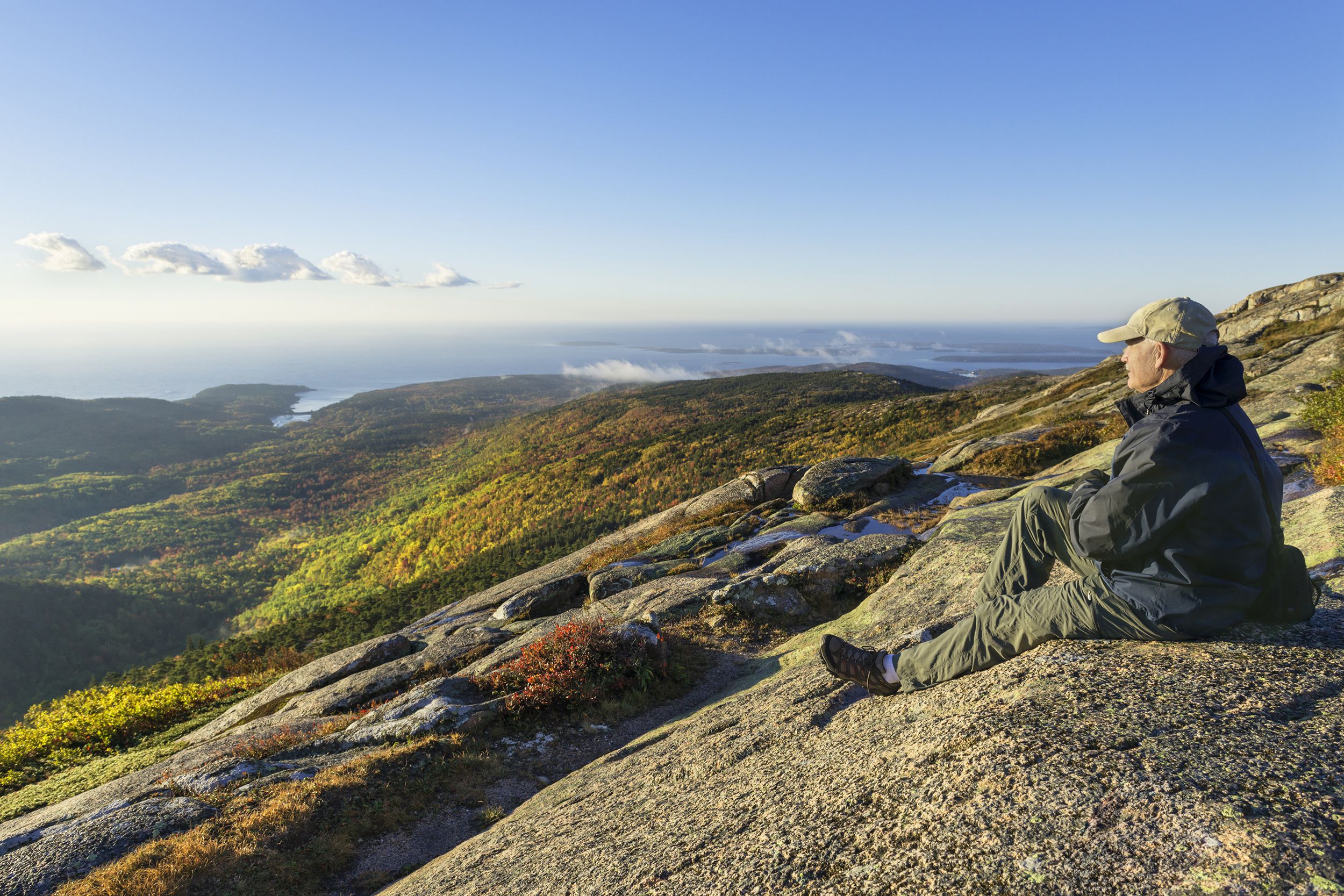 senior man looking out from top of mountain in Acadia National Park, Maine