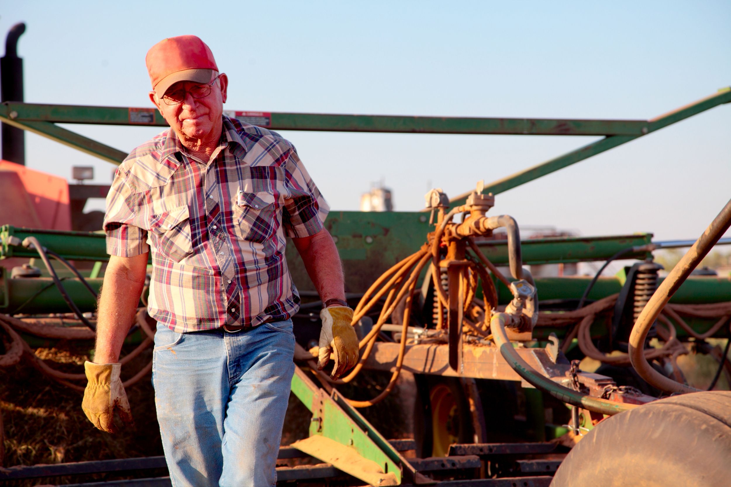 senior farmer man with plow in background