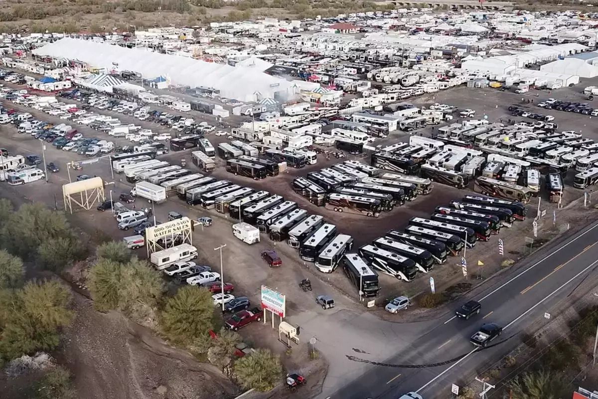 Aerial of the Quartzsite Sports, Vacation & RV Show, Quartzsite, Arizona, RVs packed in enormous parking lot, surrounded by brush, road on the lower right
