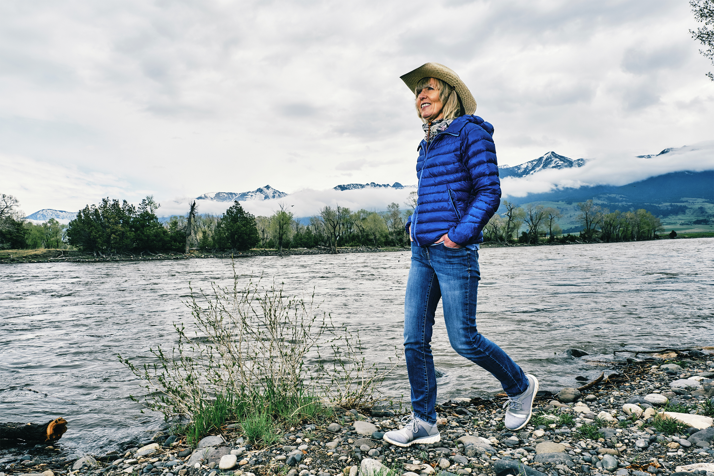 senior woman walking along shore in Montana
