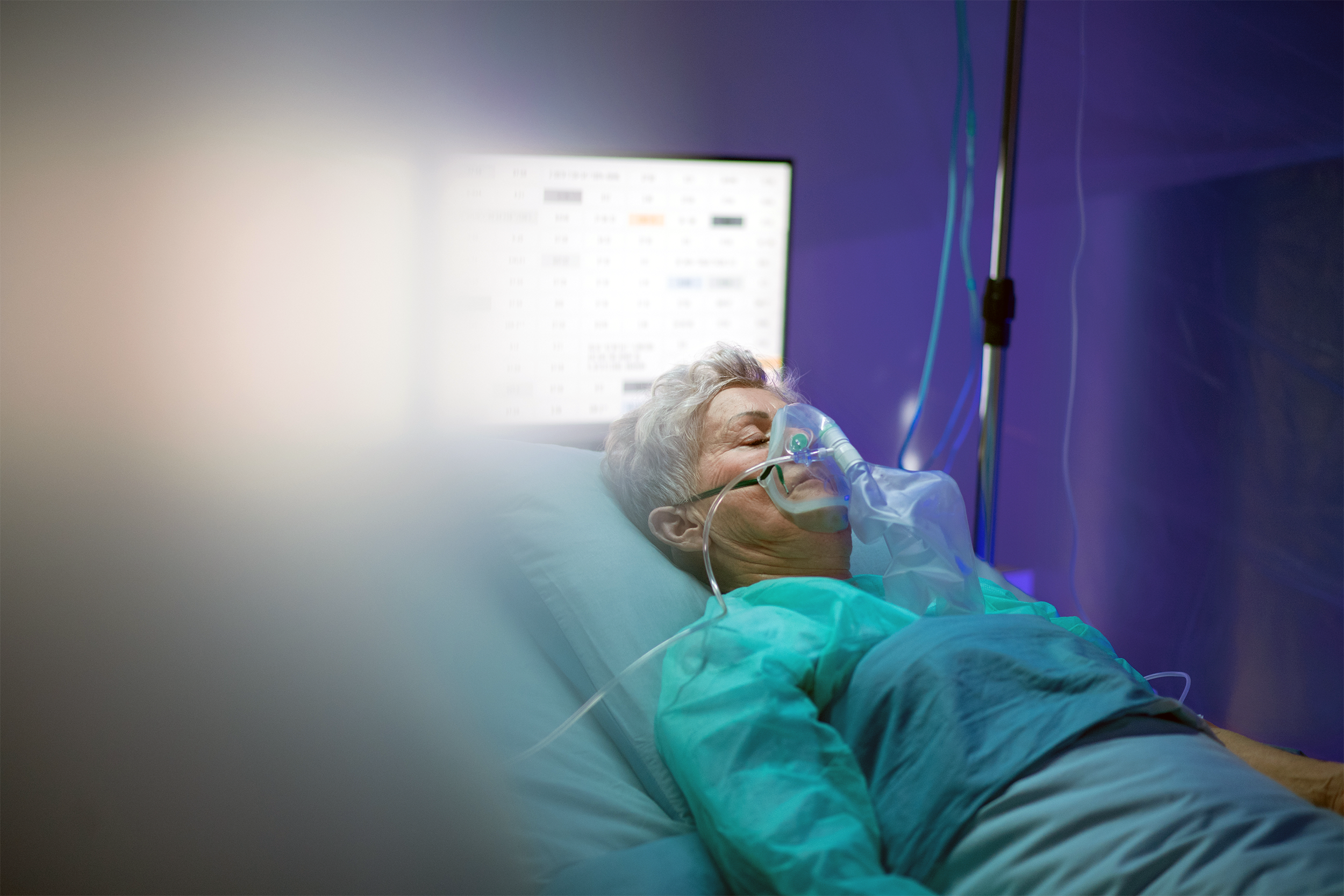 senior with covid lying in hospital bed