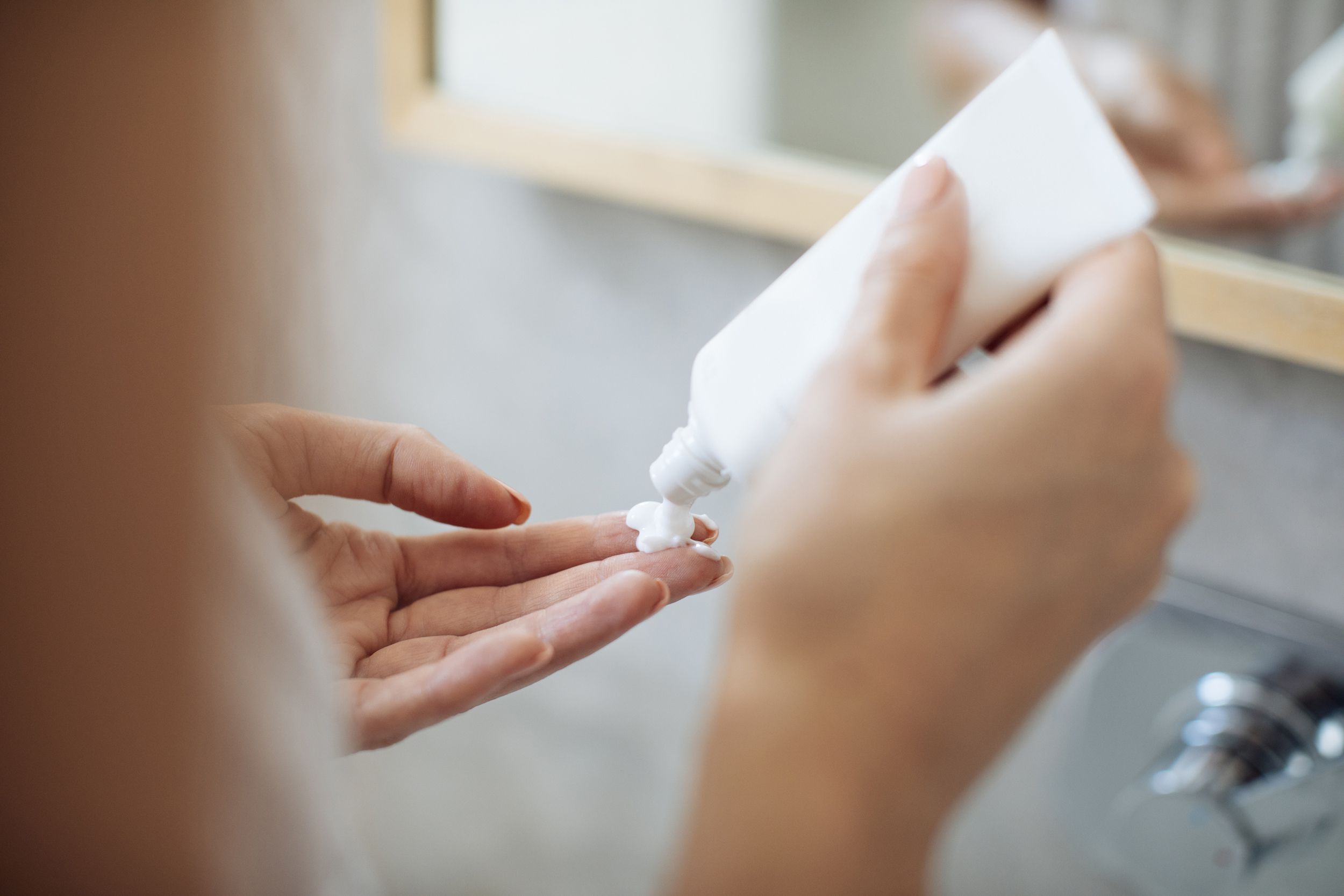 woman applying moisturizing creme on her fingers
