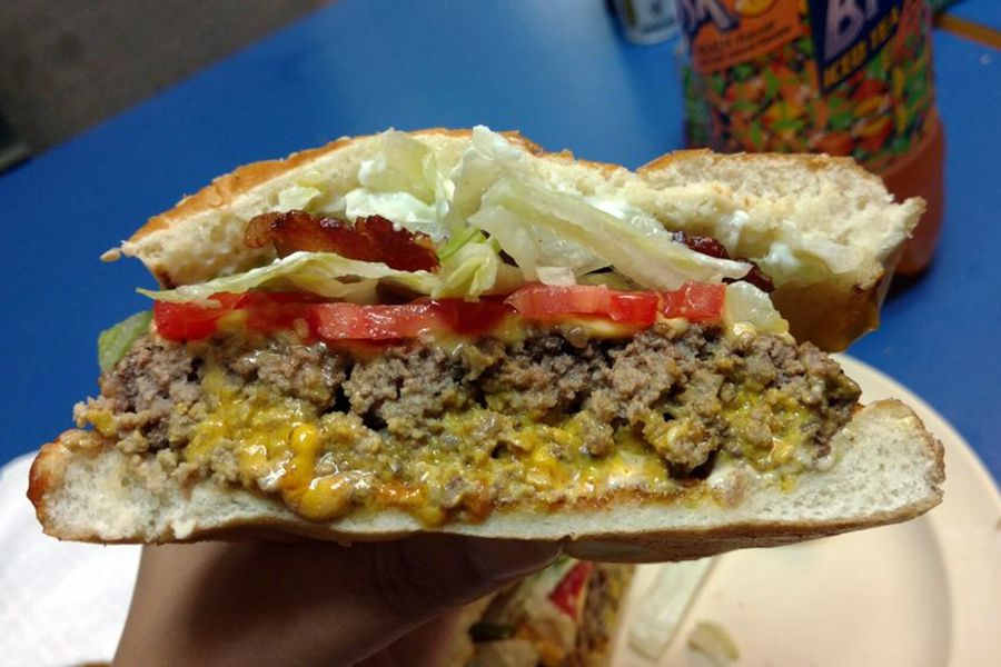 bacon cheeseburger half from sunshine general store held in hand