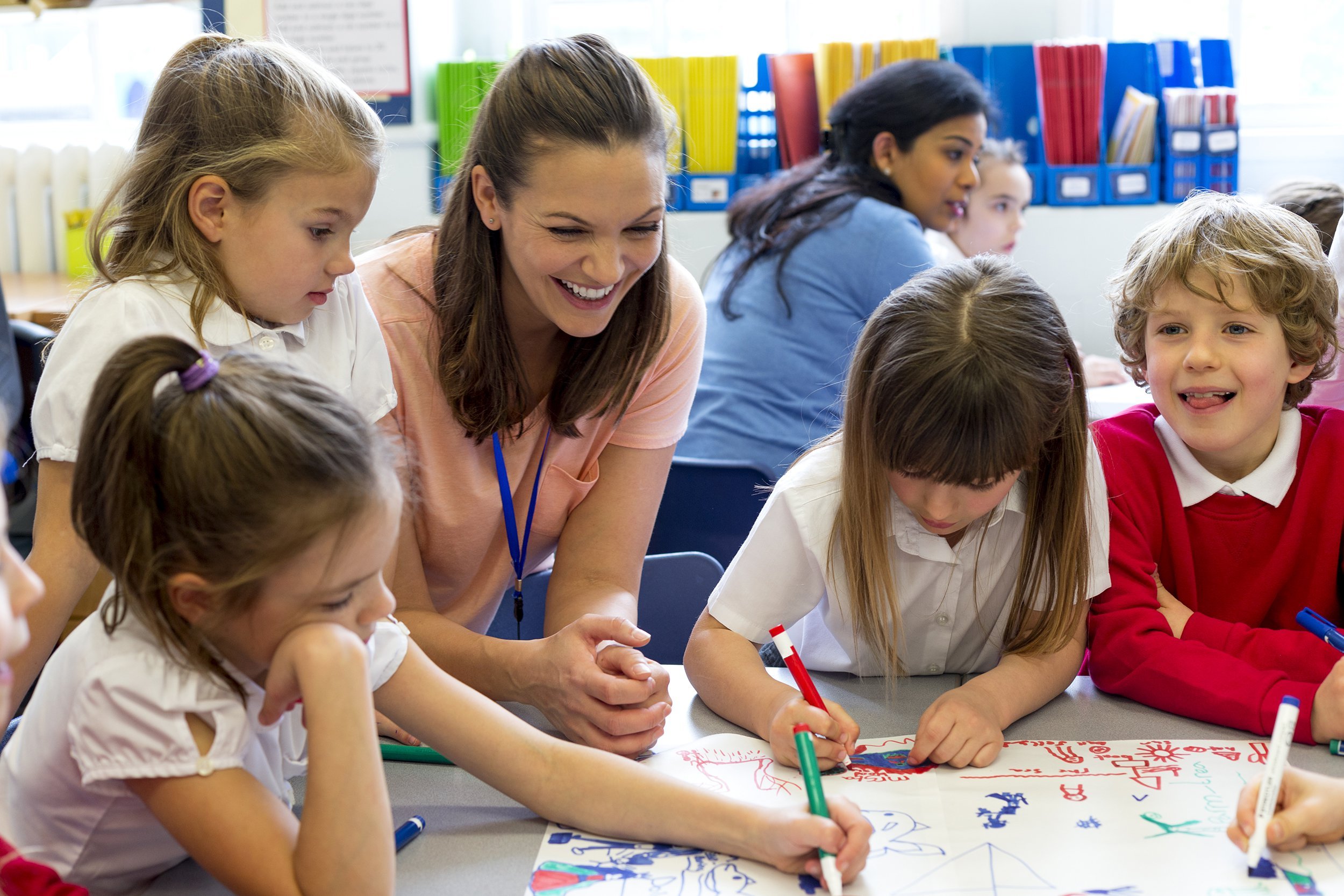 teacher and children in class drawing together
