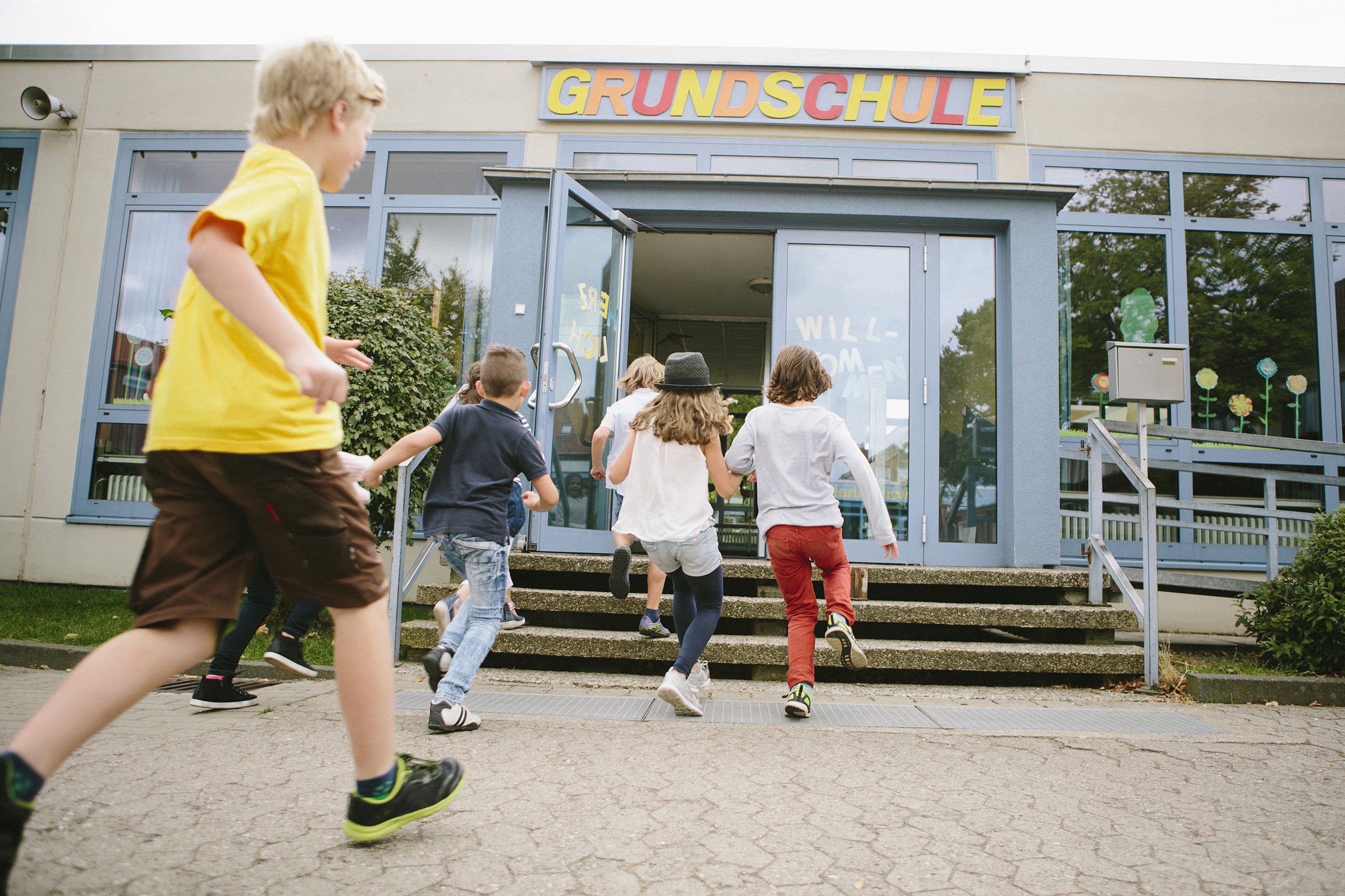 elementary school students run into school in Germany