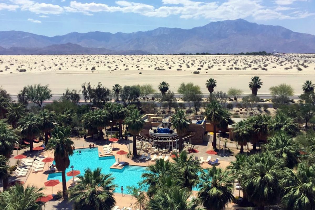 Agua Caliente Casino Resort Spa, Rancho Mirage, California, outdoor pool with palm trees around, desert with mountains in the distance