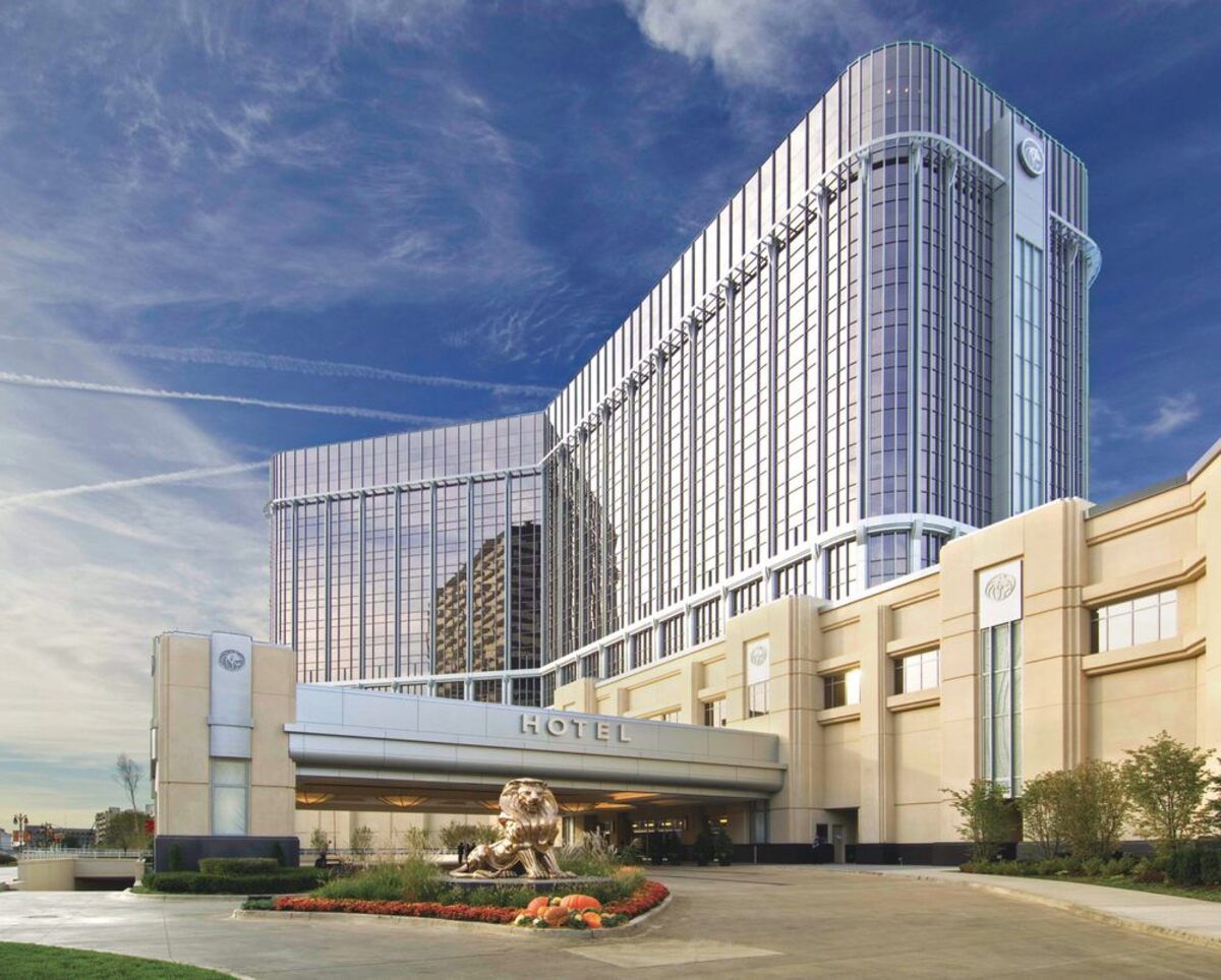MGM Grand Detroit, Detroit, front exterior of art deco architecture building with driveway in the foreground, expansive blue sky with white string clouds on a sunny day