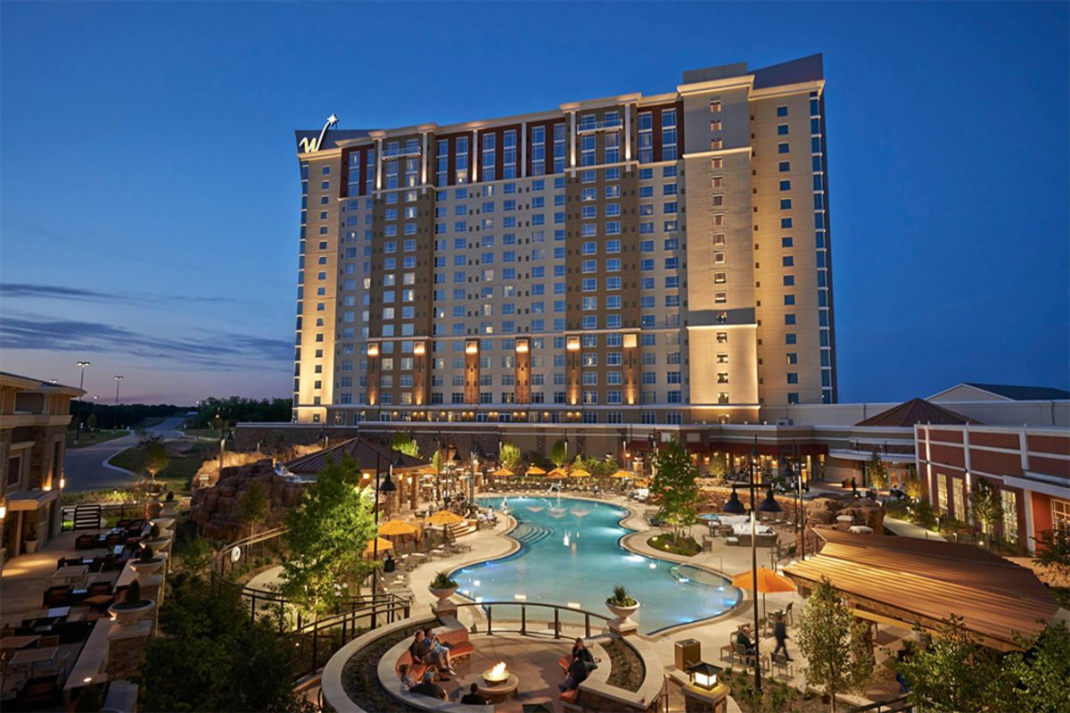 WinStar World Casino, Thackerville, Oklahoma, front exterior building with large pool in the foreground, lights on during early evening