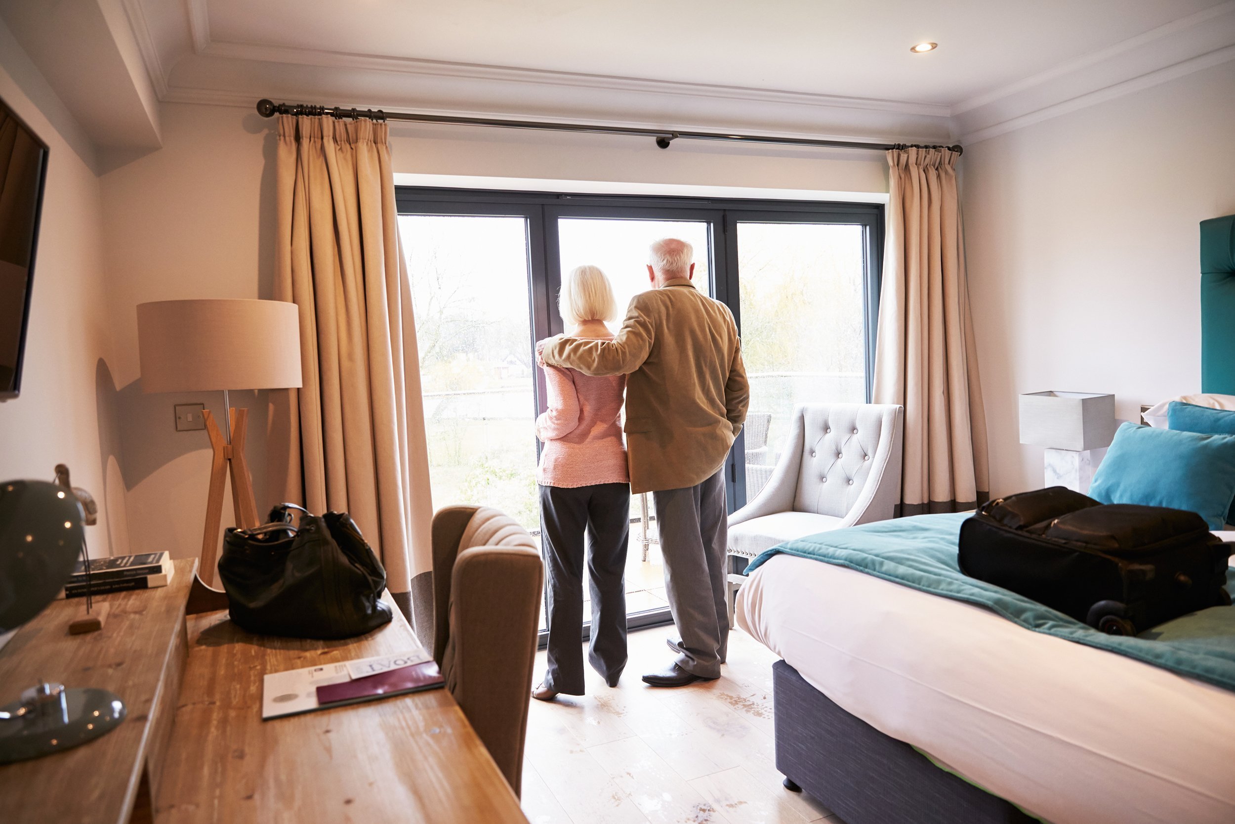 senior couple arriving in hotel room on vacation