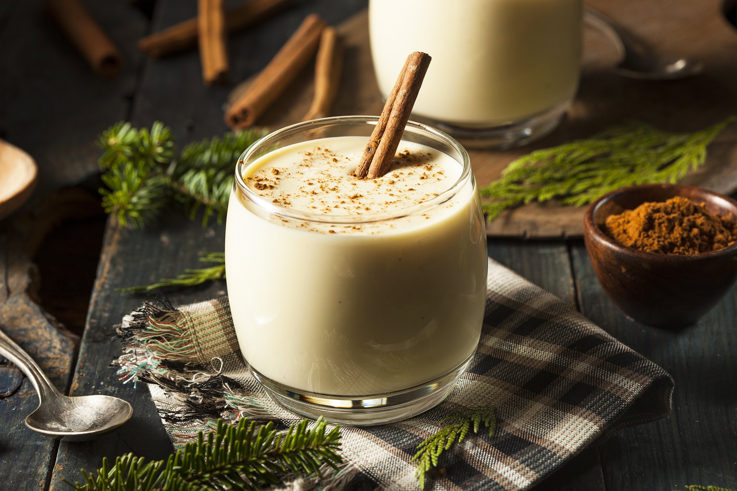 homemade white holiday eggnog with a cinnamon stick