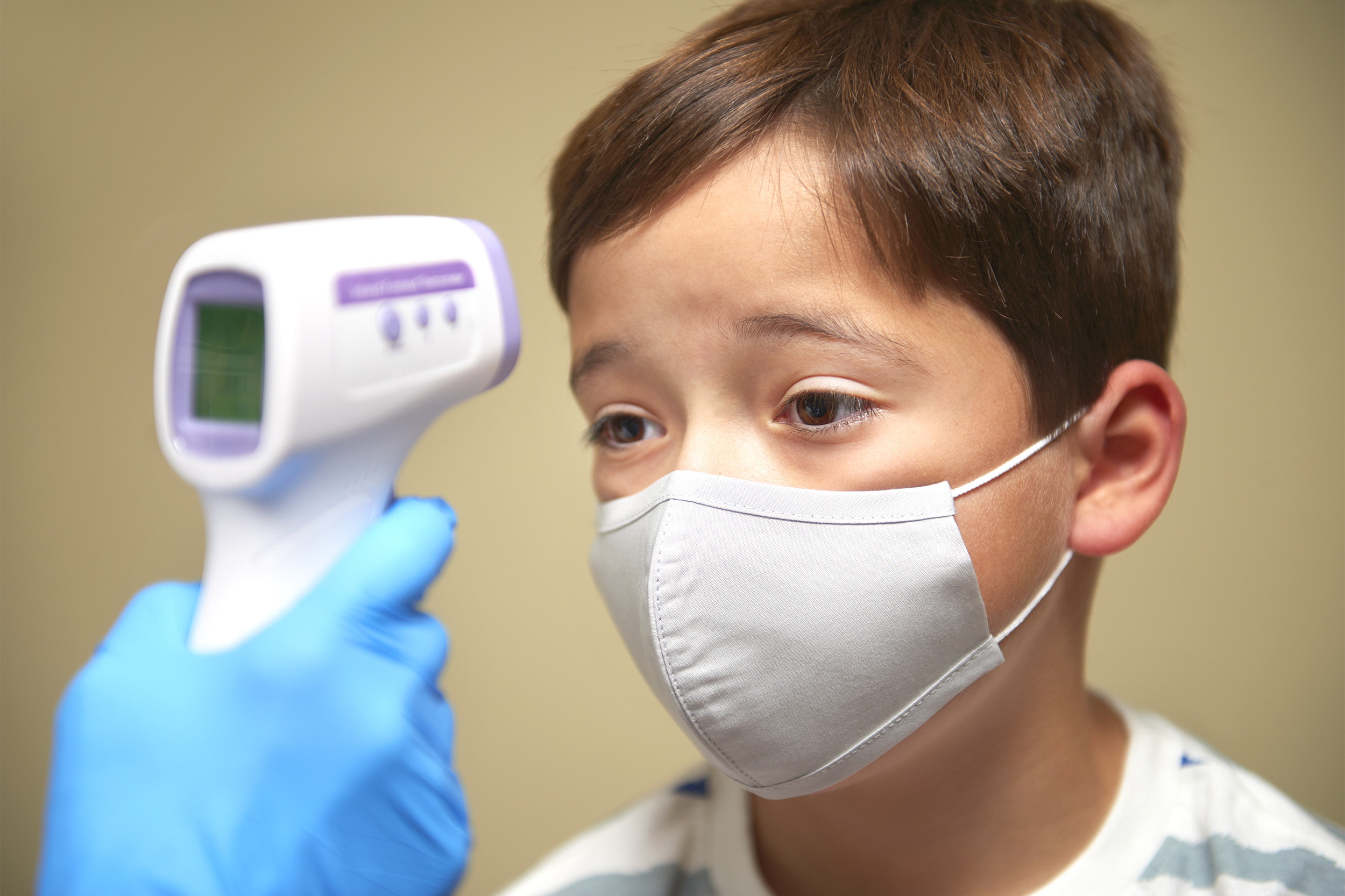 9 year old boy having temperature taken, during covid-19 test