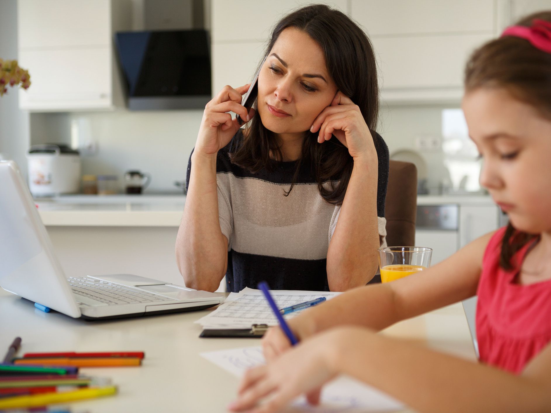 Working mom using mobile phone and laptop at home